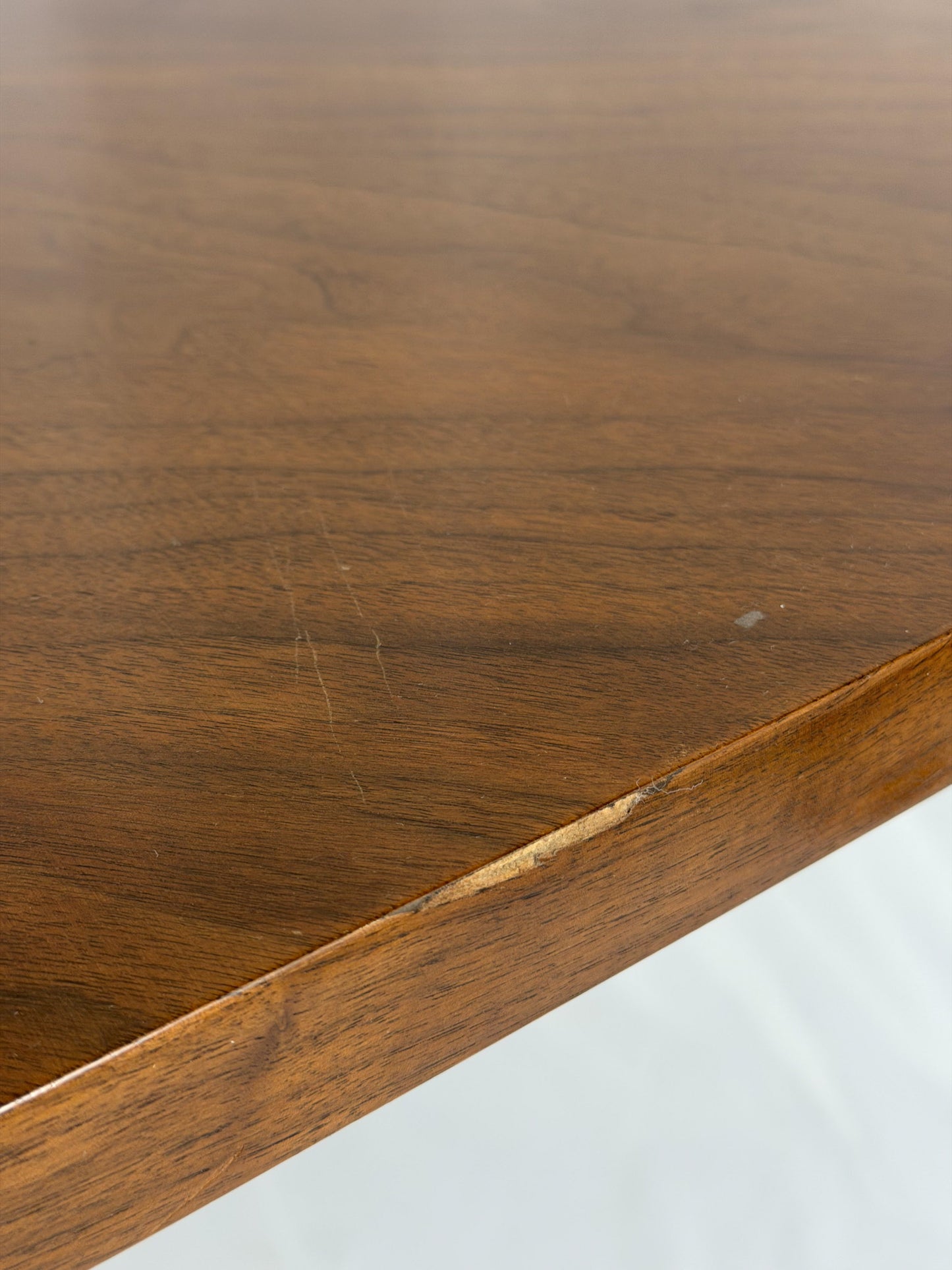 Close-up of a wooden surface with visible grain and a scratch.
