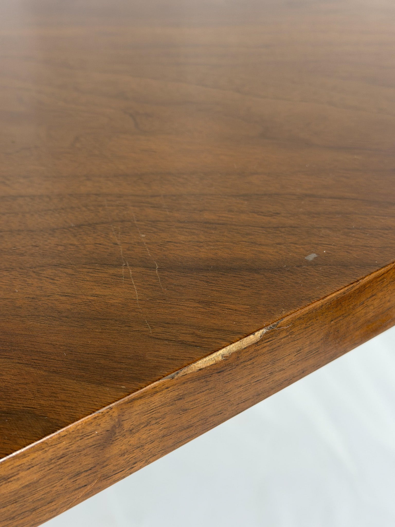 Close-up of a wooden surface with visible grain and a scratch.