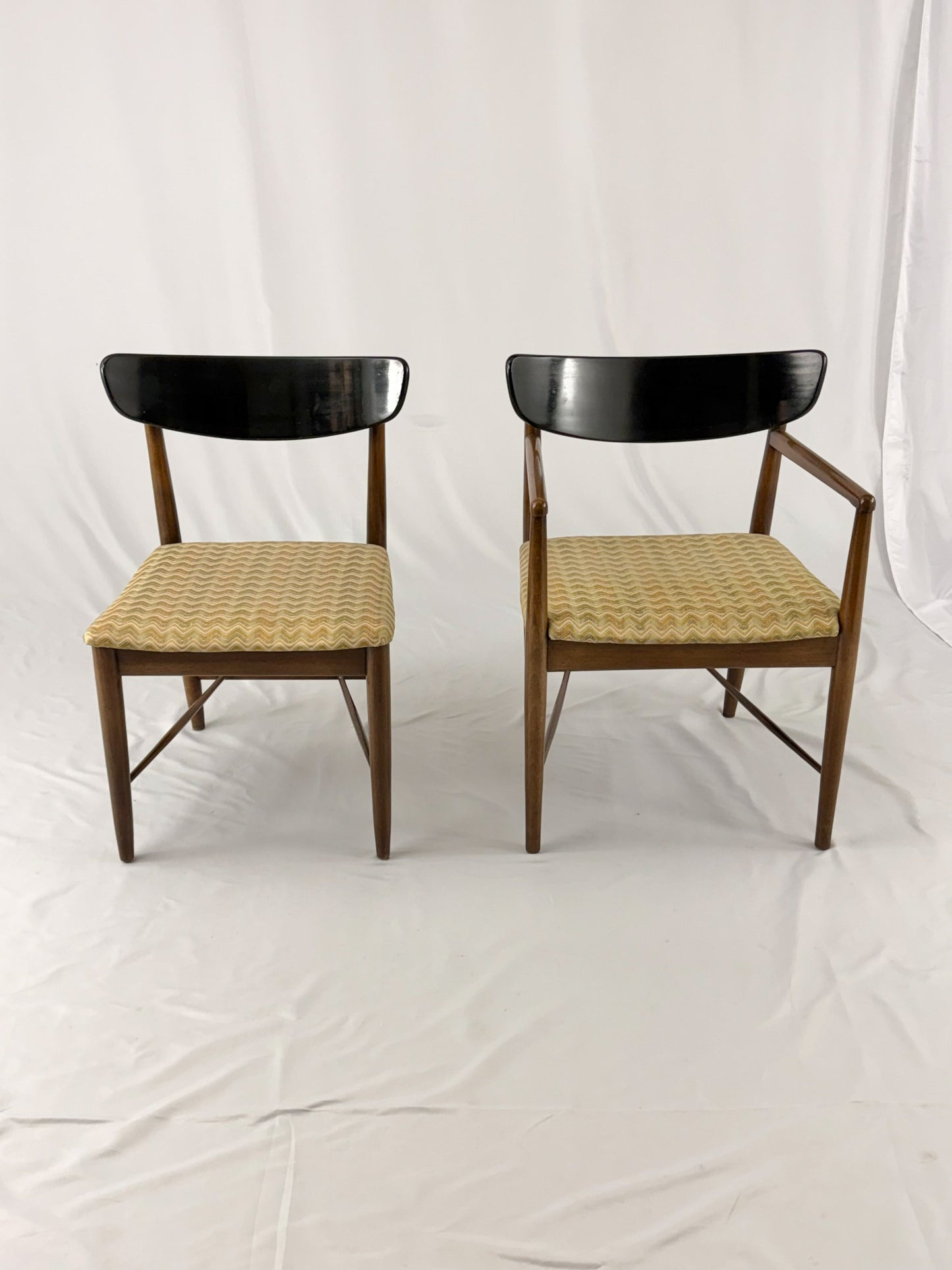 Two wooden chairs with upholstered seats on a white background