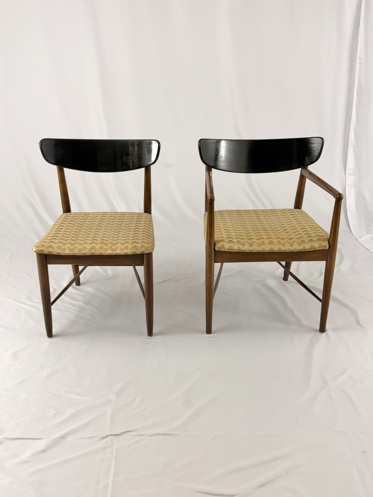 Two wooden chairs with upholstered seats on a white background