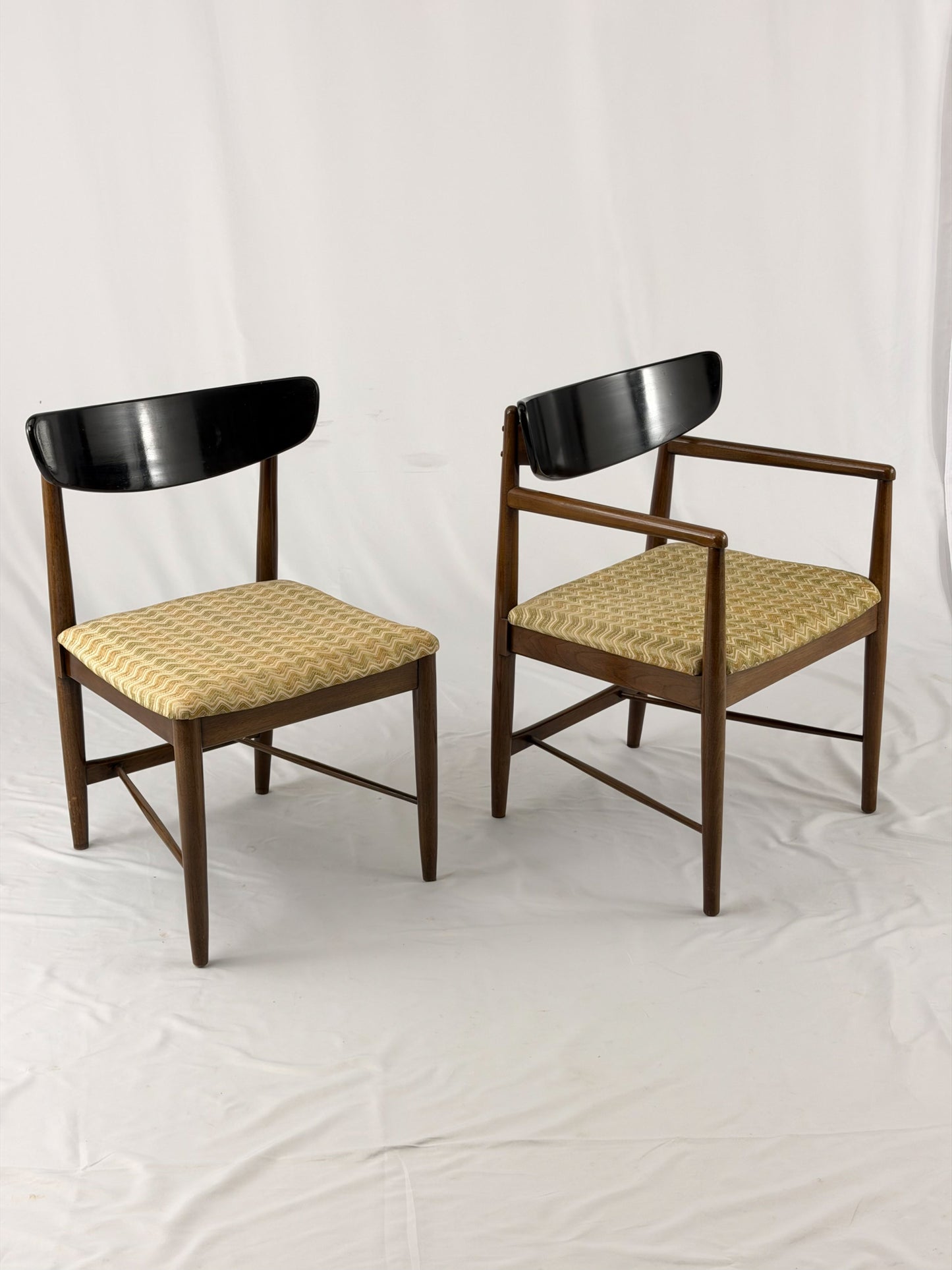 Two wooden chairs with upholstered seats on a white background