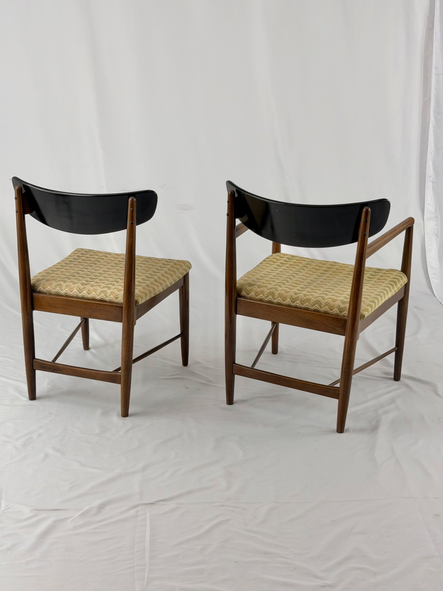 Two wooden chairs with upholstered seats on a white background