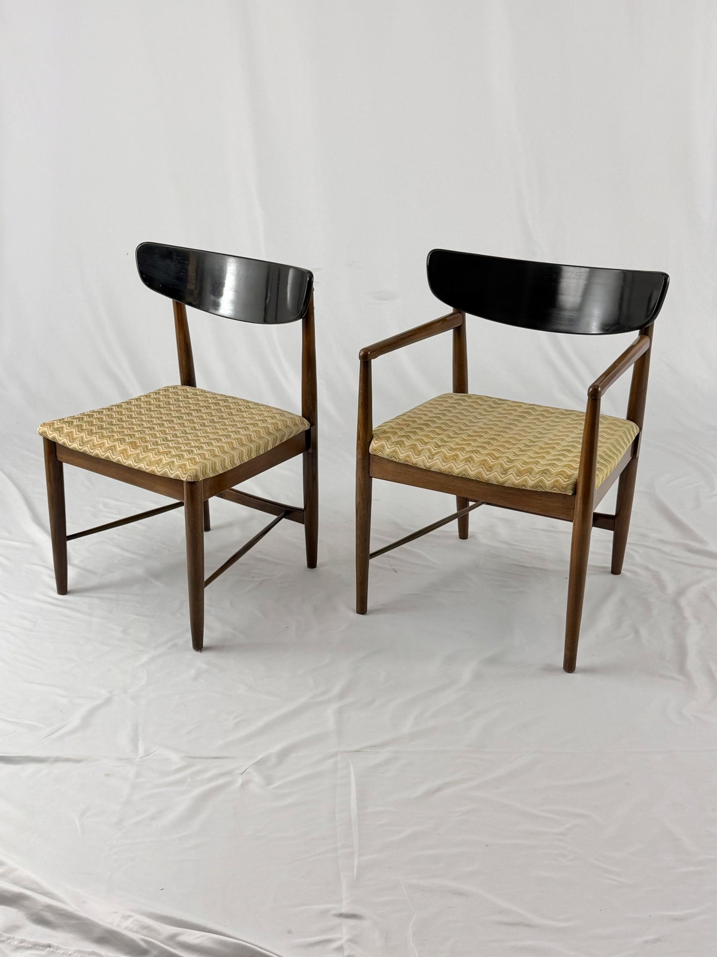 Two wooden chairs with upholstered seats on a white background
