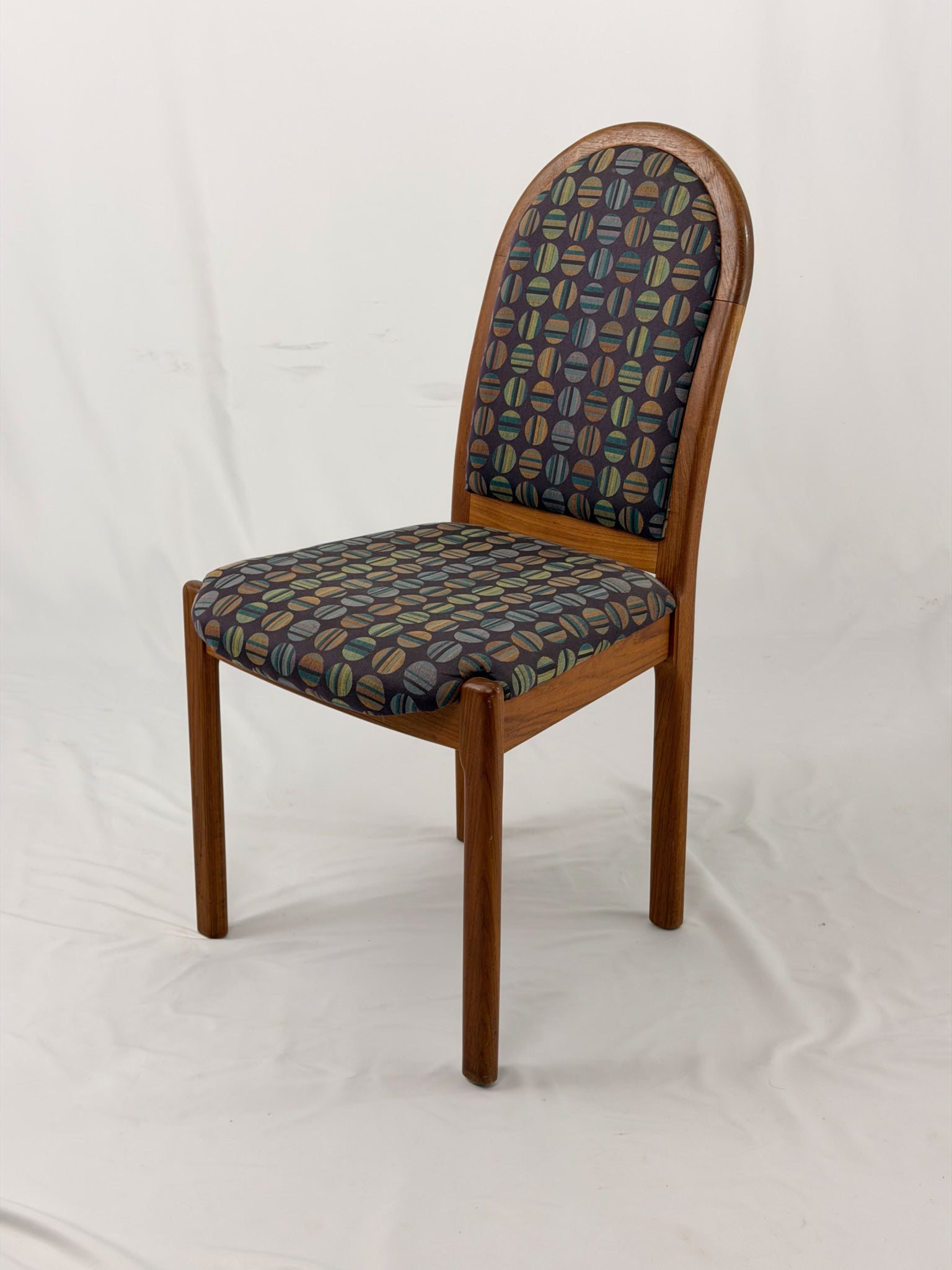 Wooden chair with patterned fabric seat and backrest on a white background
