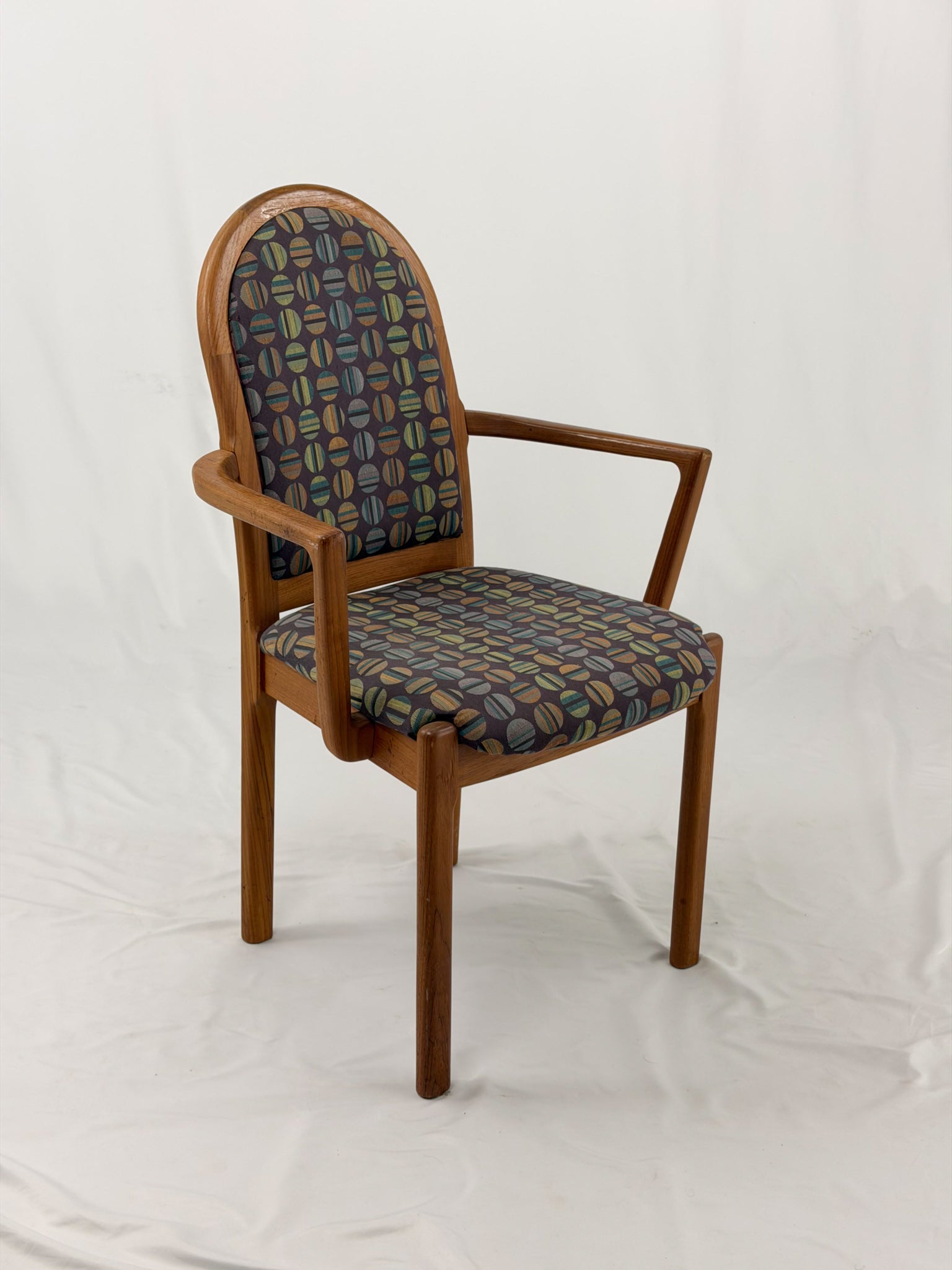 Wooden chair with patterned fabric seat and backrest on a white background
