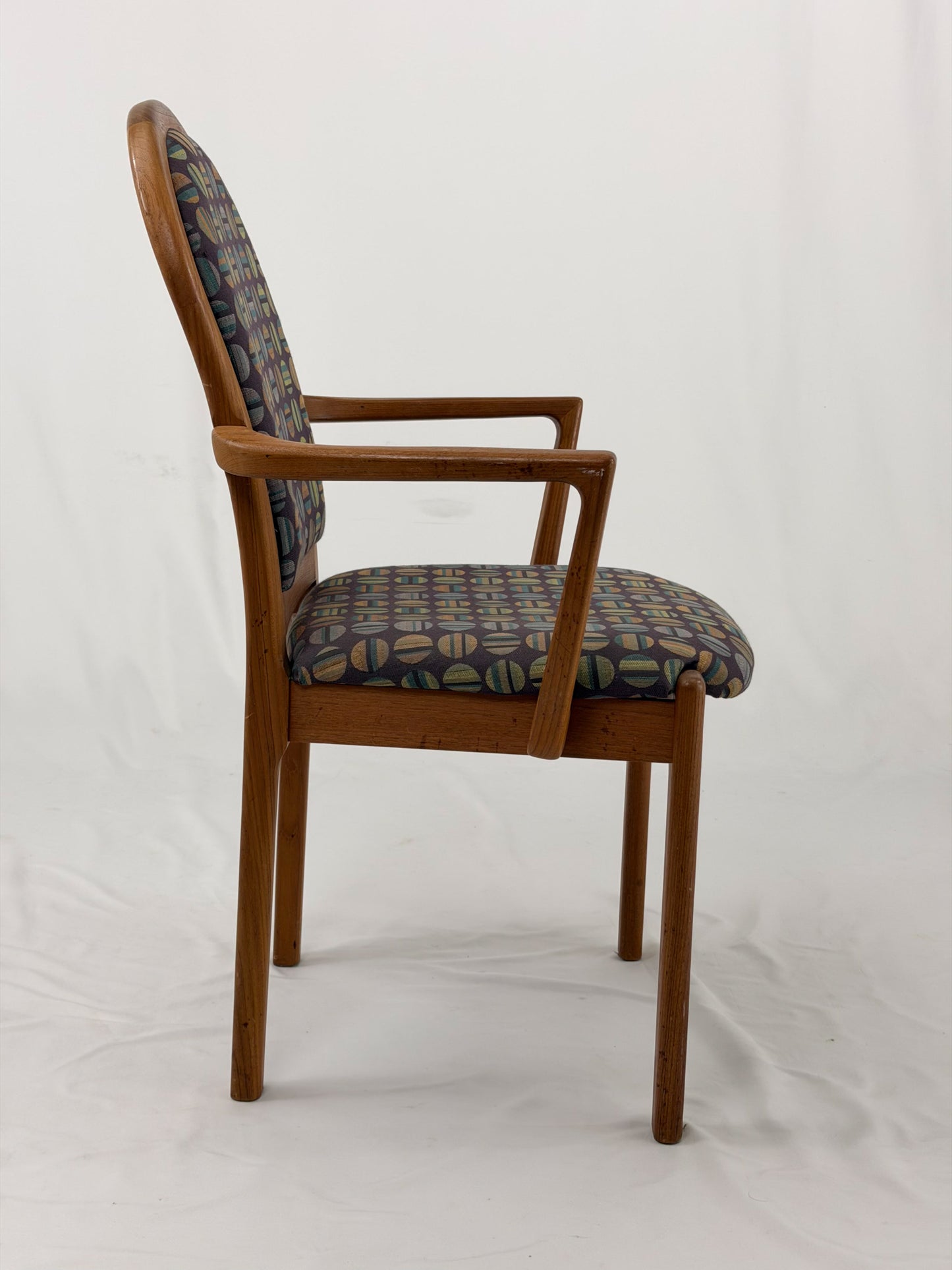 Wooden chair with patterned fabric seat and backrest on a white background
