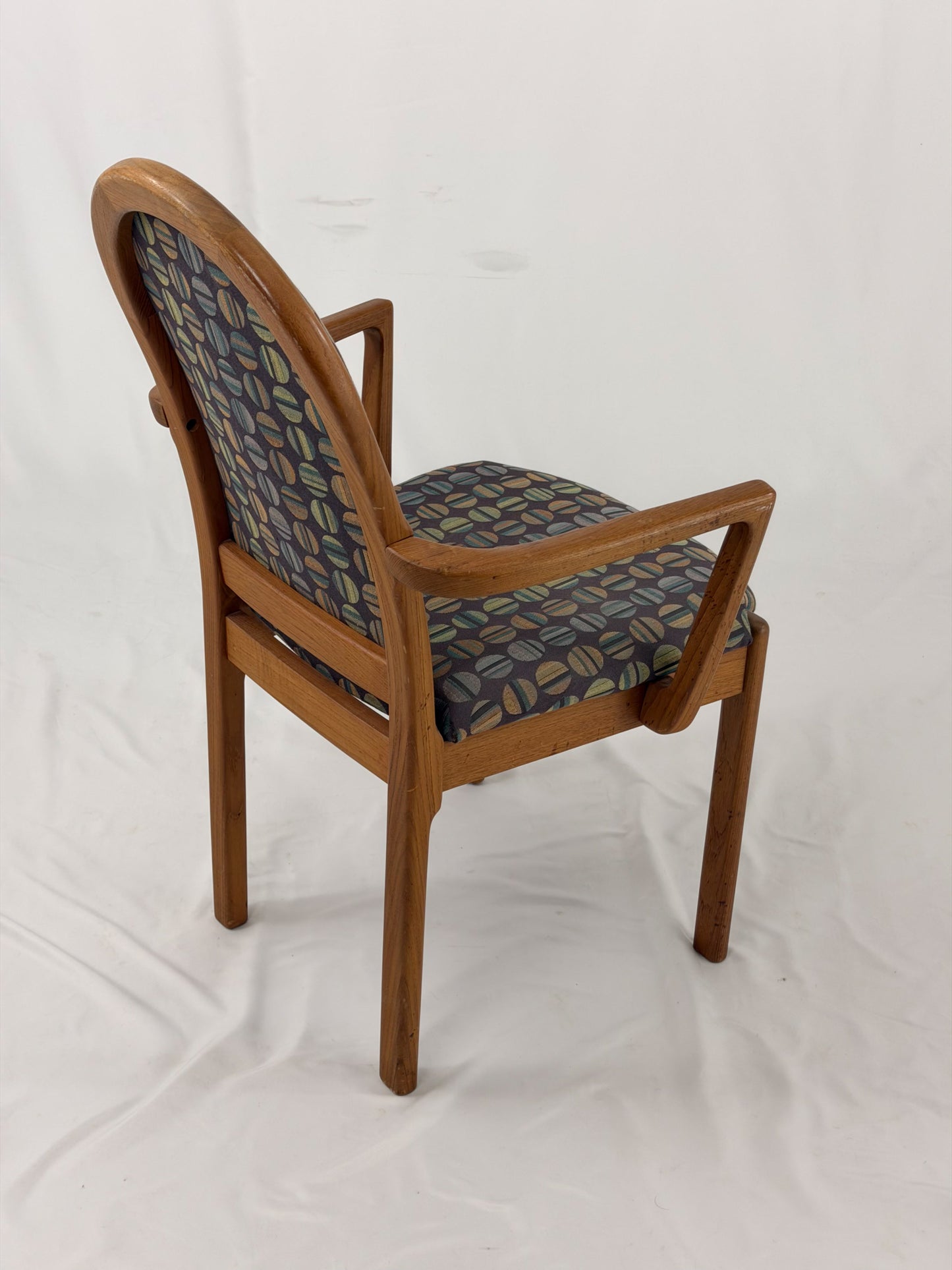 Wooden chair with patterned fabric seat and backrest on a white background
