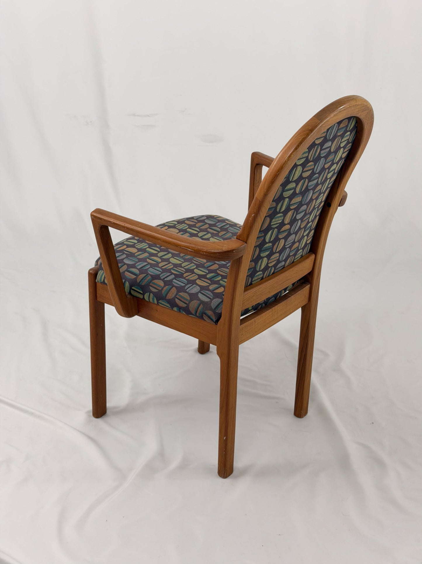 Wooden chair with patterned fabric seat and backrest on a white background