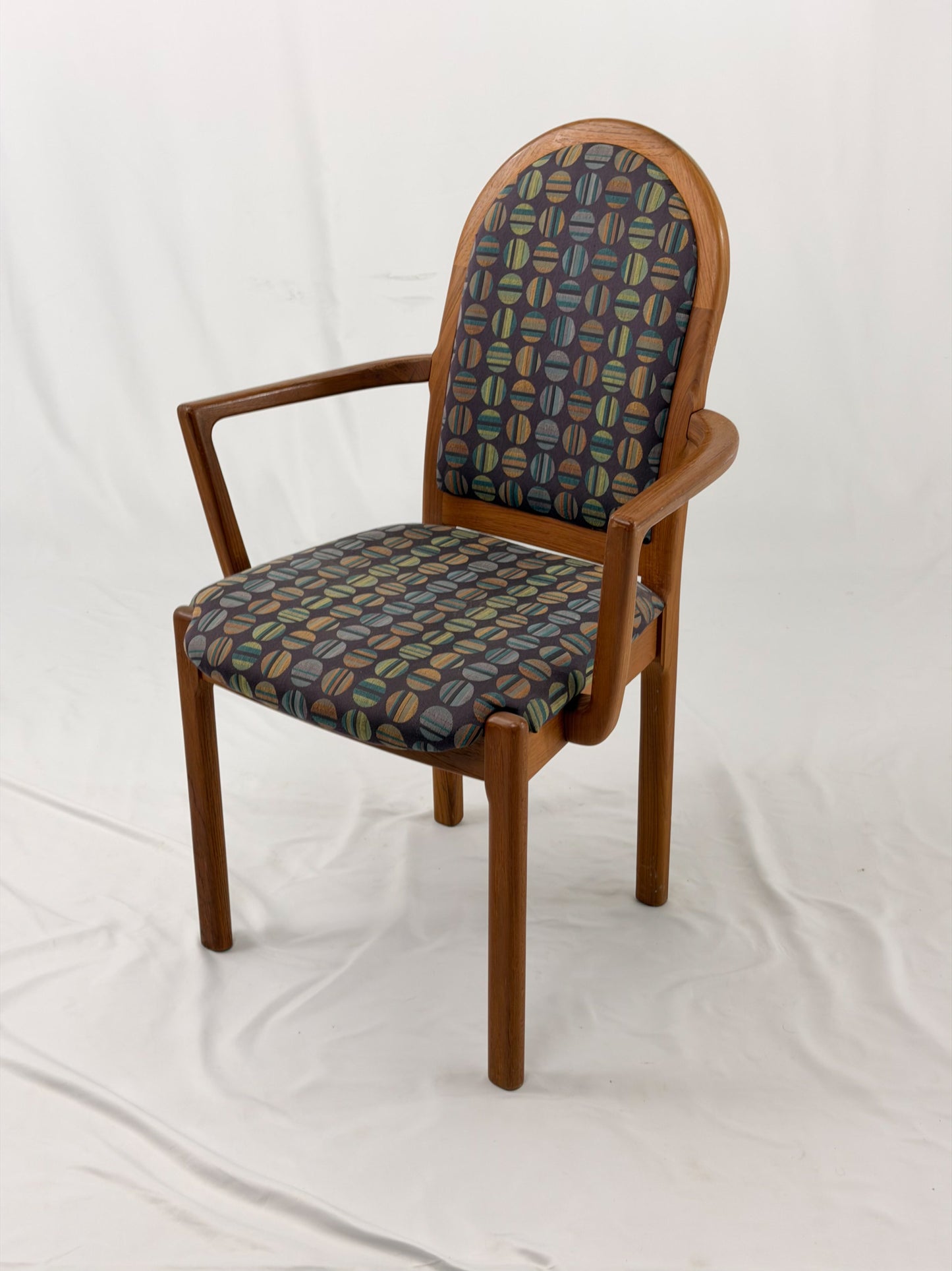 Wooden chair with patterned fabric seat and backrest on a white background