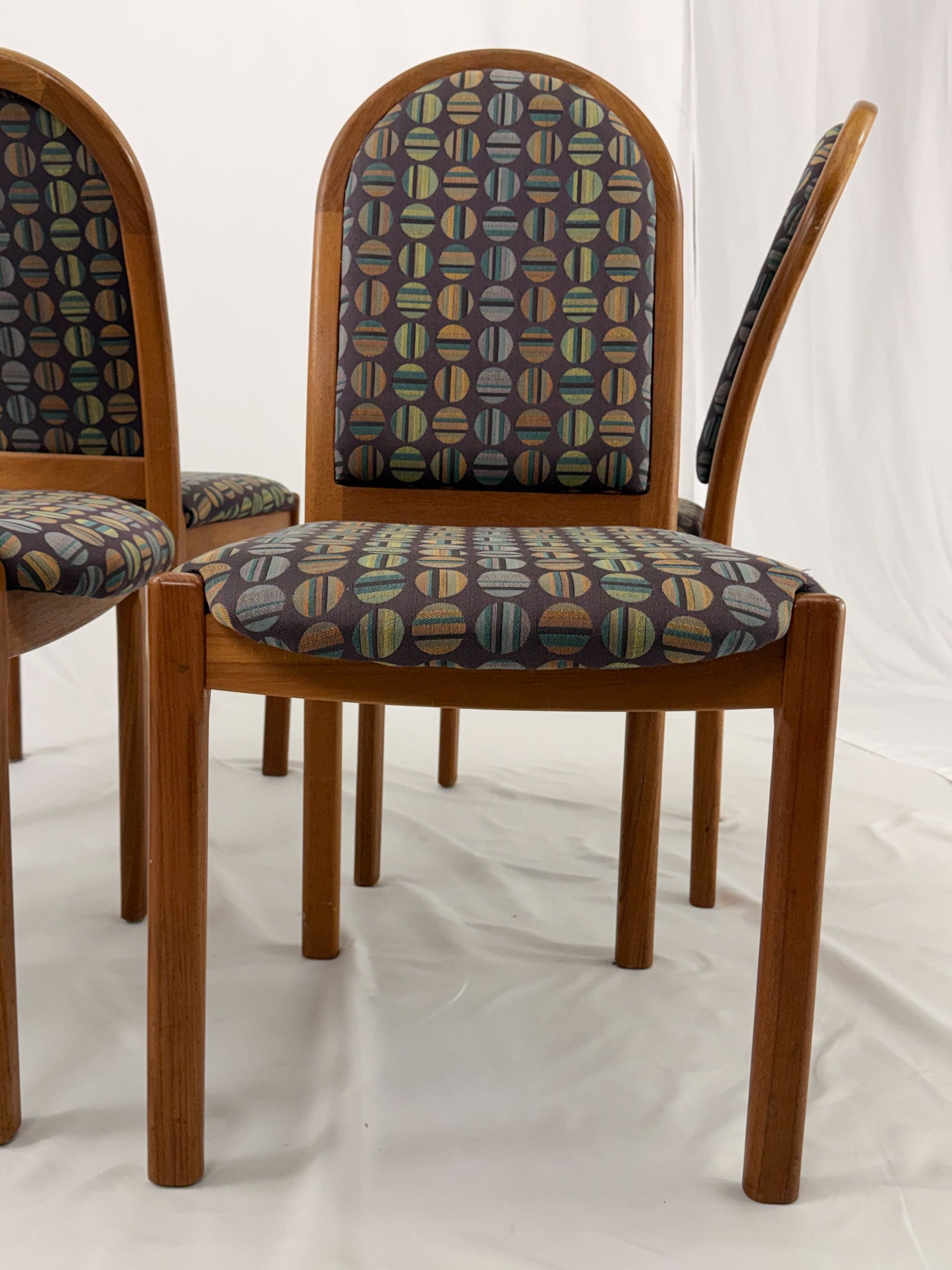 Wooden chairs with patterned cushions on a white background
