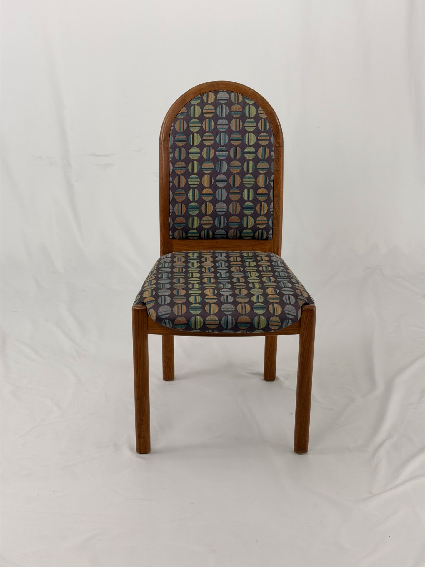 Wooden chair with patterned fabric seat and backrest on a white background