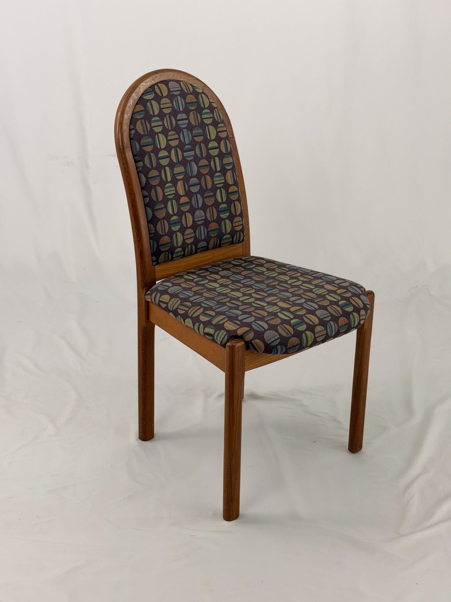 Wooden chair with patterned fabric seat and backrest on a white background