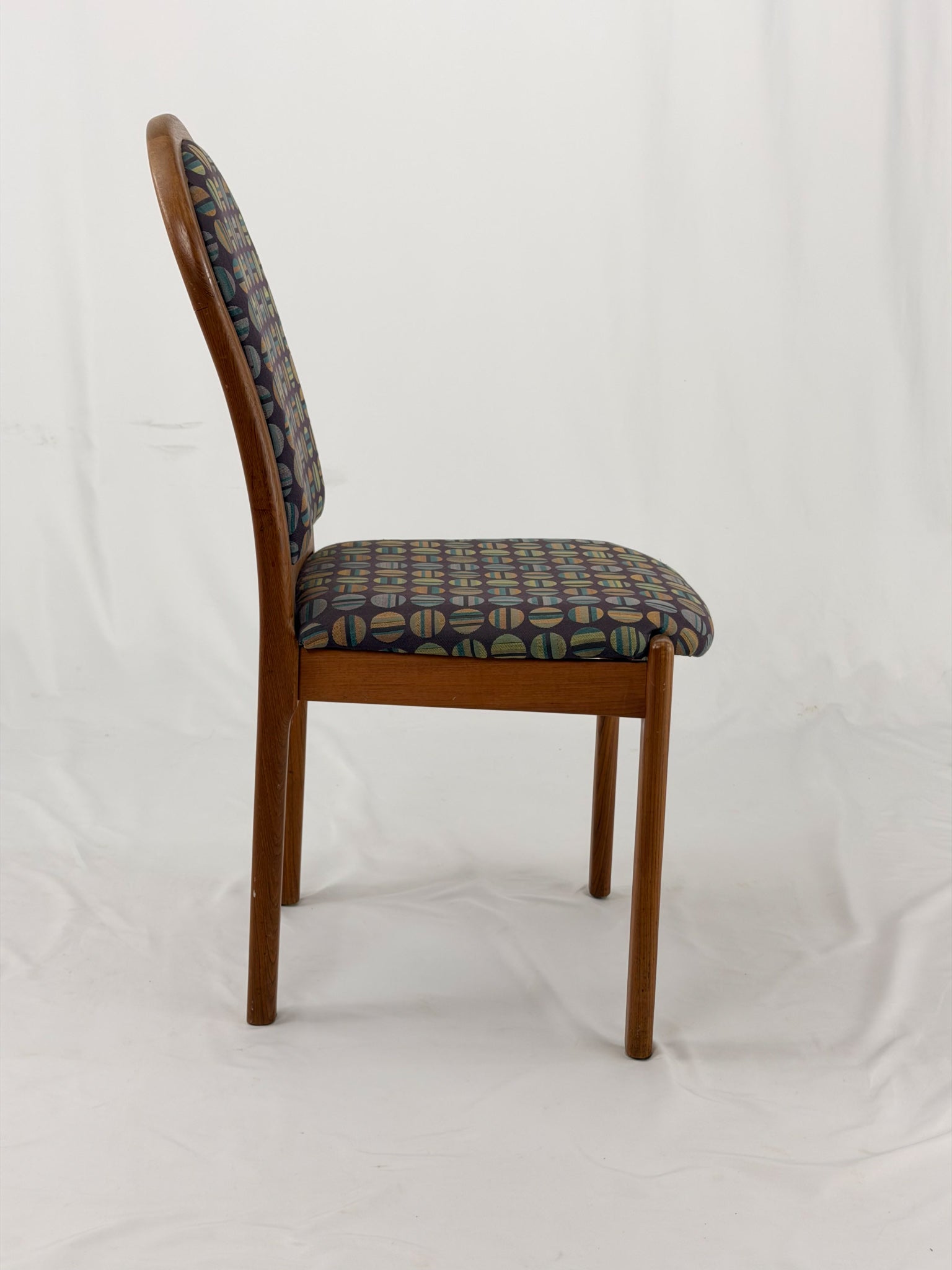 Wooden chair with patterned fabric seat and backrest on a white background