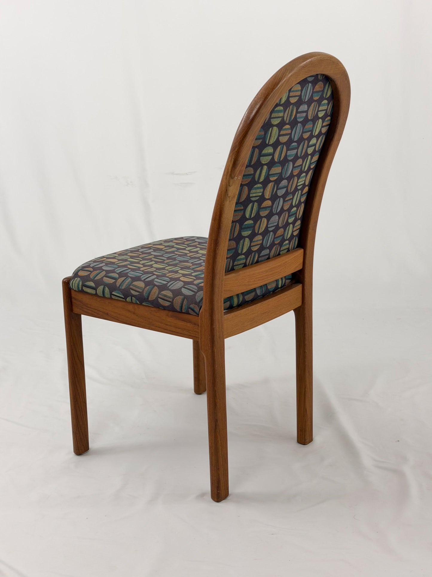 Wooden chair with patterned fabric seat and backrest on a white background