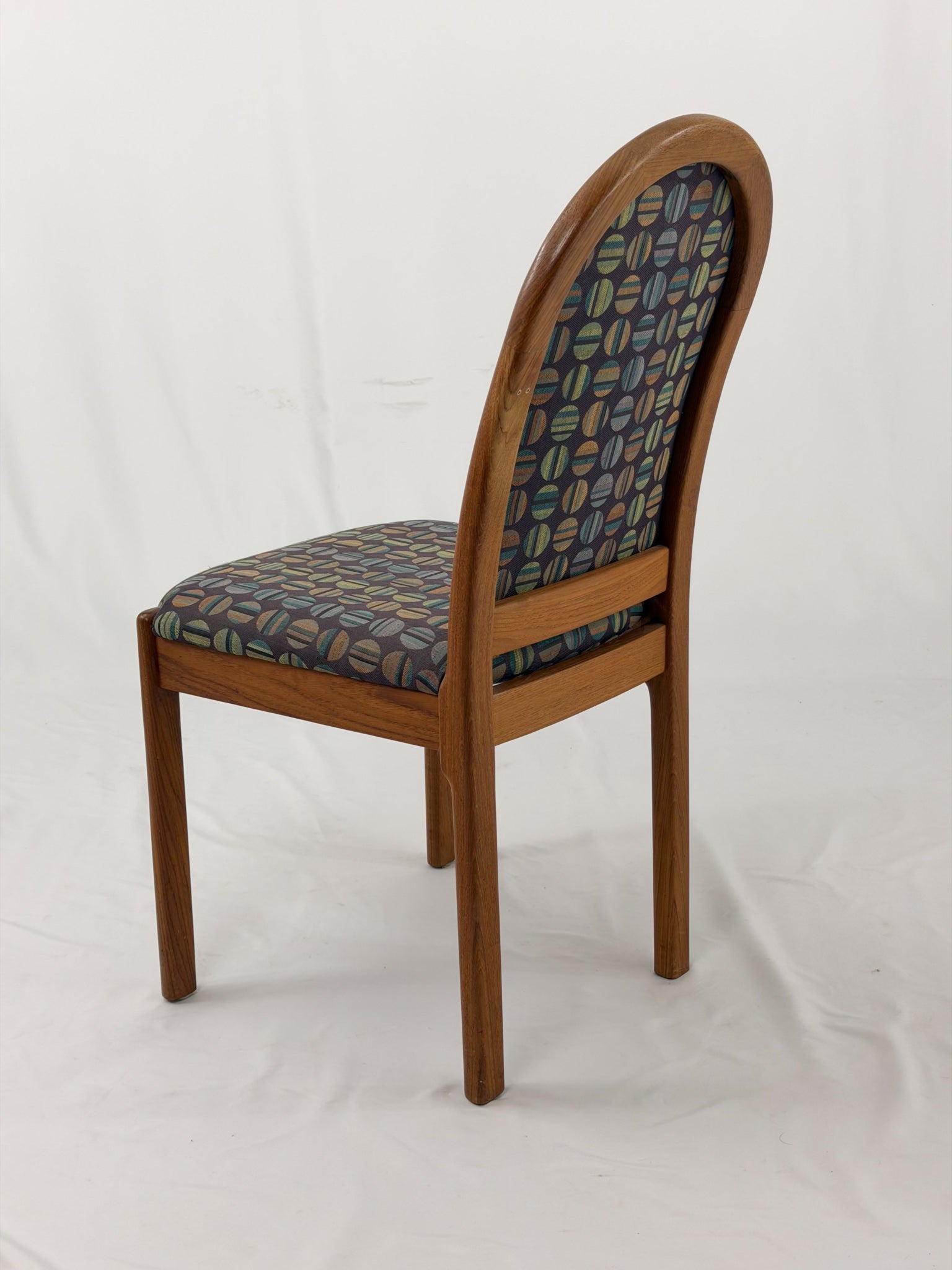 Wooden chair with patterned fabric seat and backrest on a white background