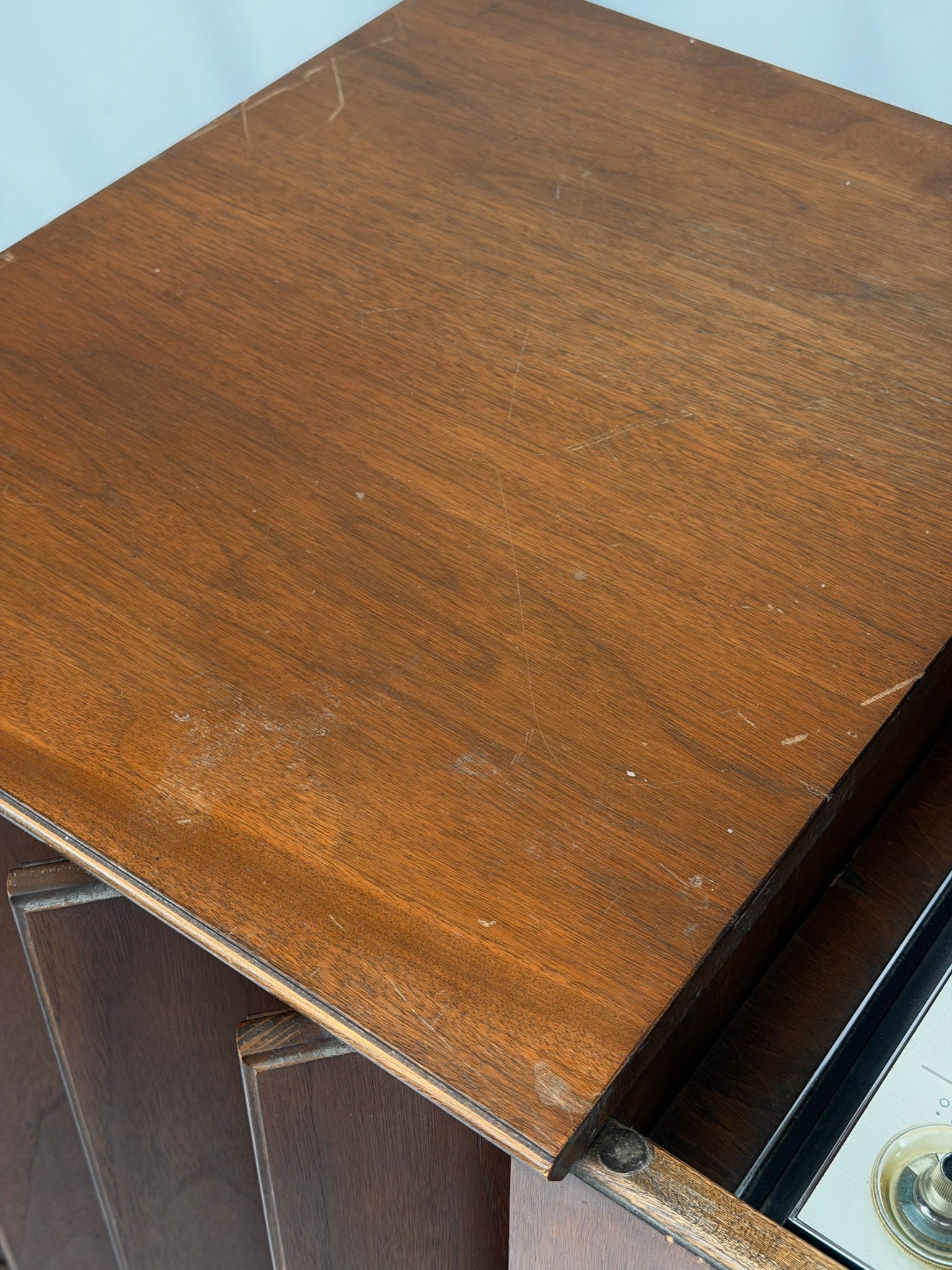 Vintage record player with a turntable and control panel on a wooden surface.