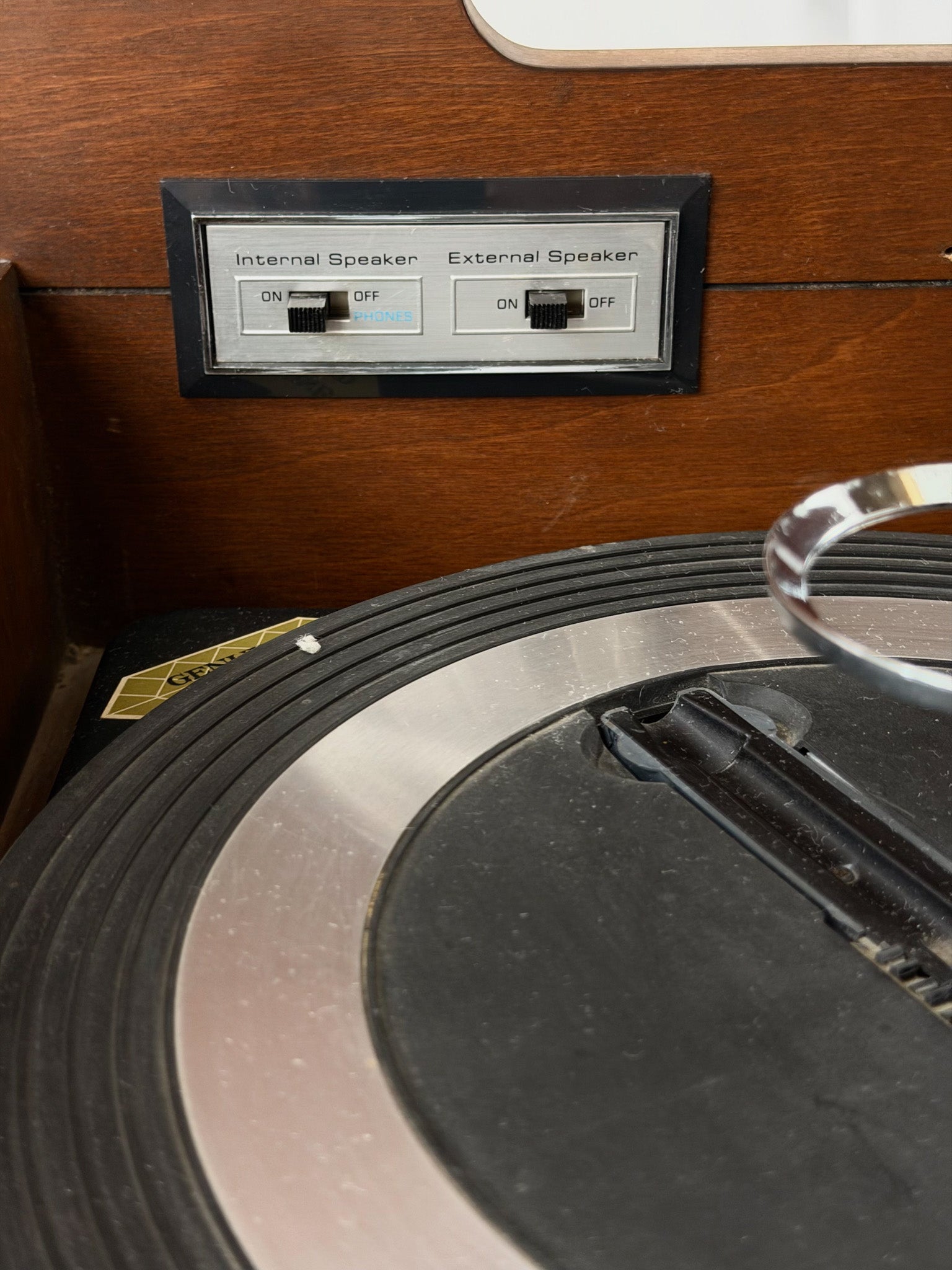 Vintage record player with a turntable and control panel on a wooden surface.