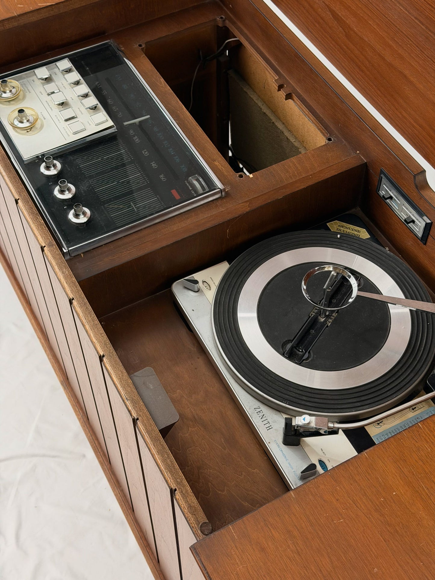 Vintage-style turntable with a record inside, placed on a wooden surface.