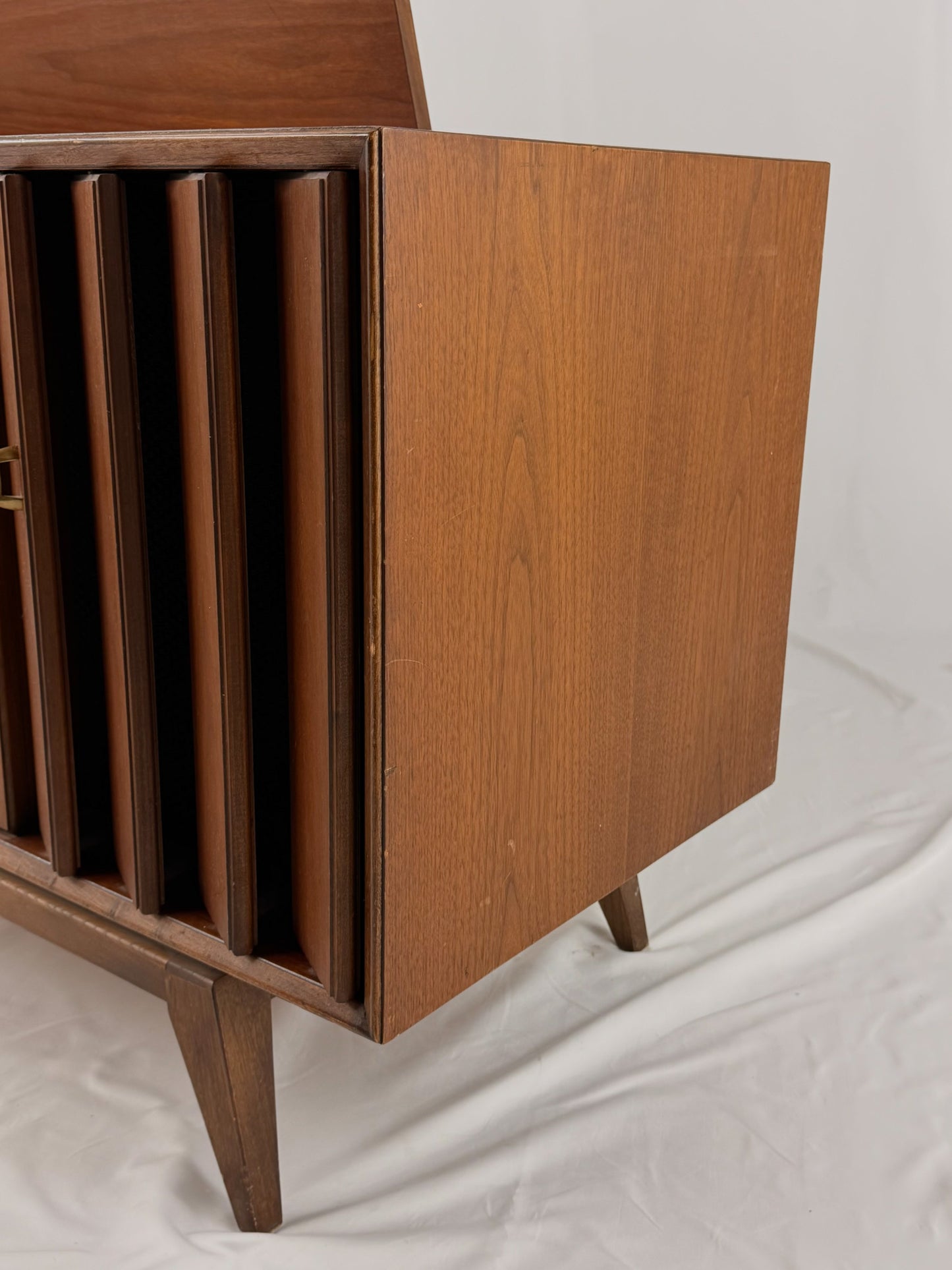 Vintage record player with a turntable and control panel on a wooden surface.