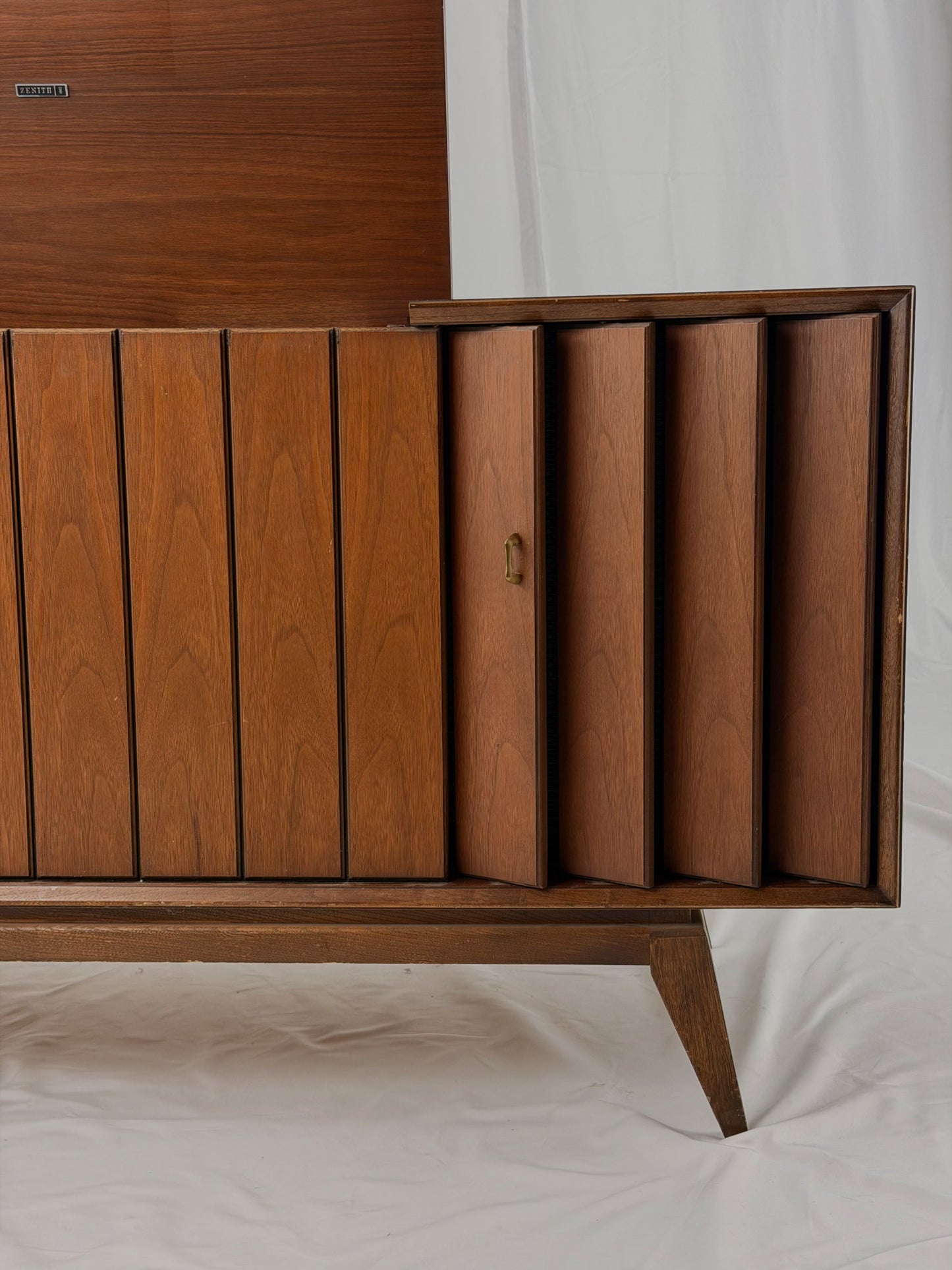 Vintage record player with a turntable and control panel on a wooden surface.
