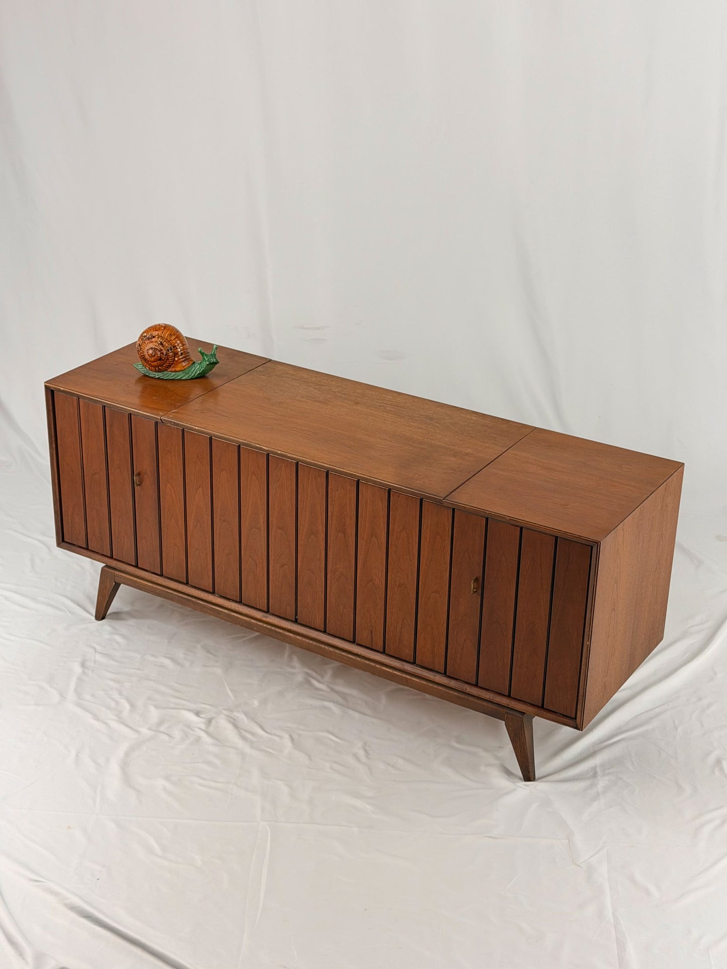 Vintage record player with a turntable and control panel on a wooden surface.