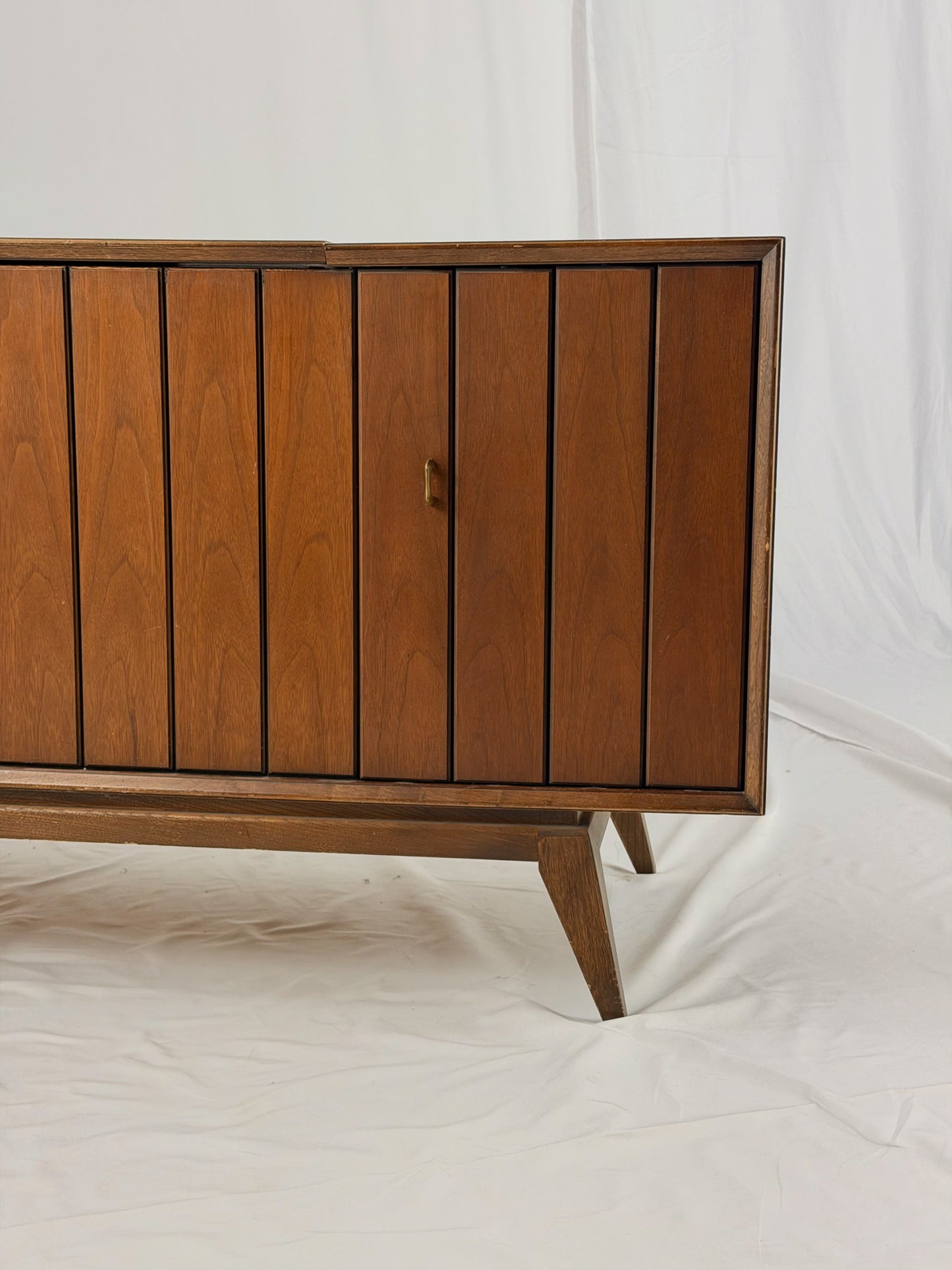 Vintage record player with a turntable and control panel on a wooden surface.