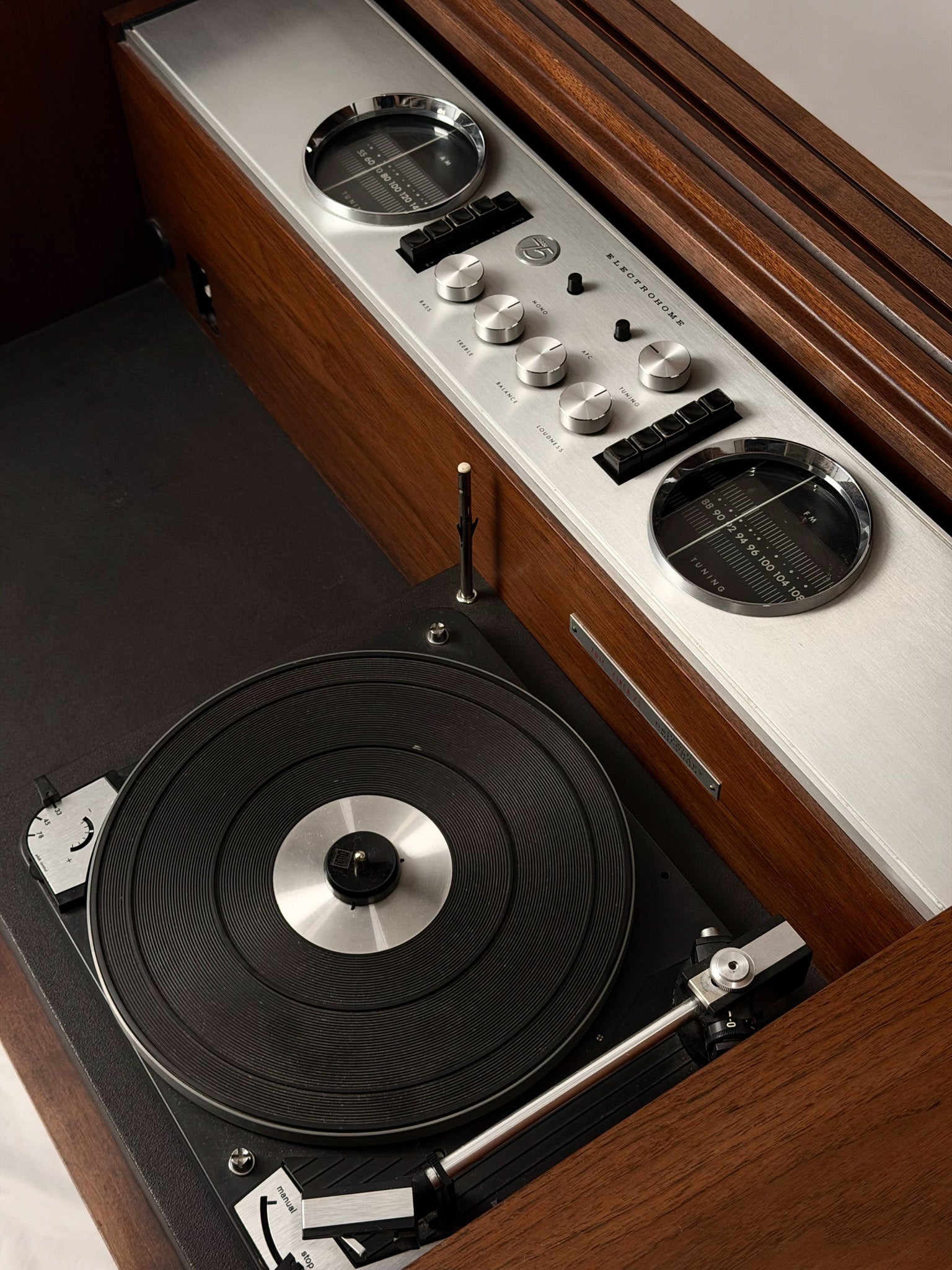 Vintage-style turntable with wooden cabinet and control panel.