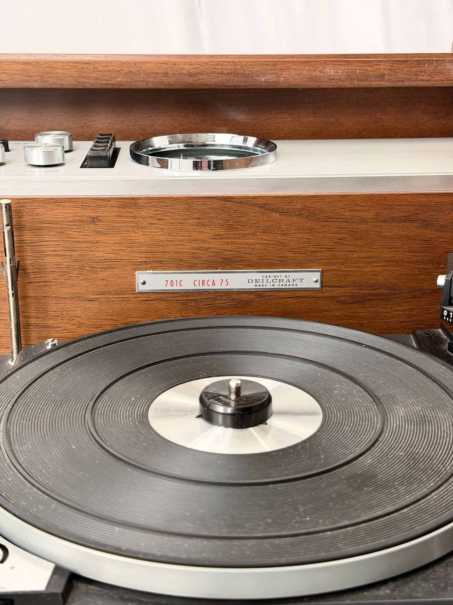 Close-up of a vintage record player with wooden casing and turntable.