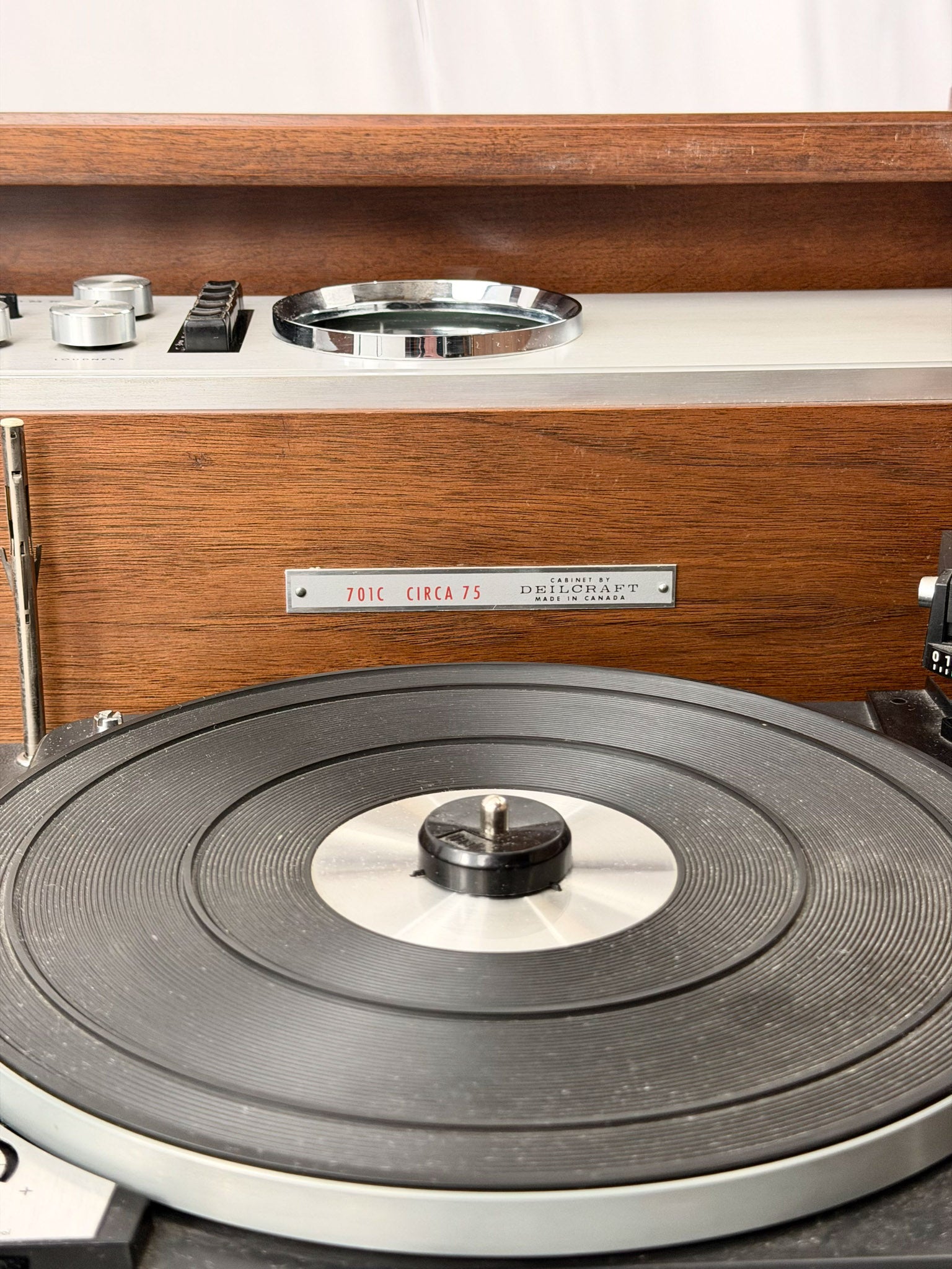 Close-up of a vintage record player with wooden casing and turntable.