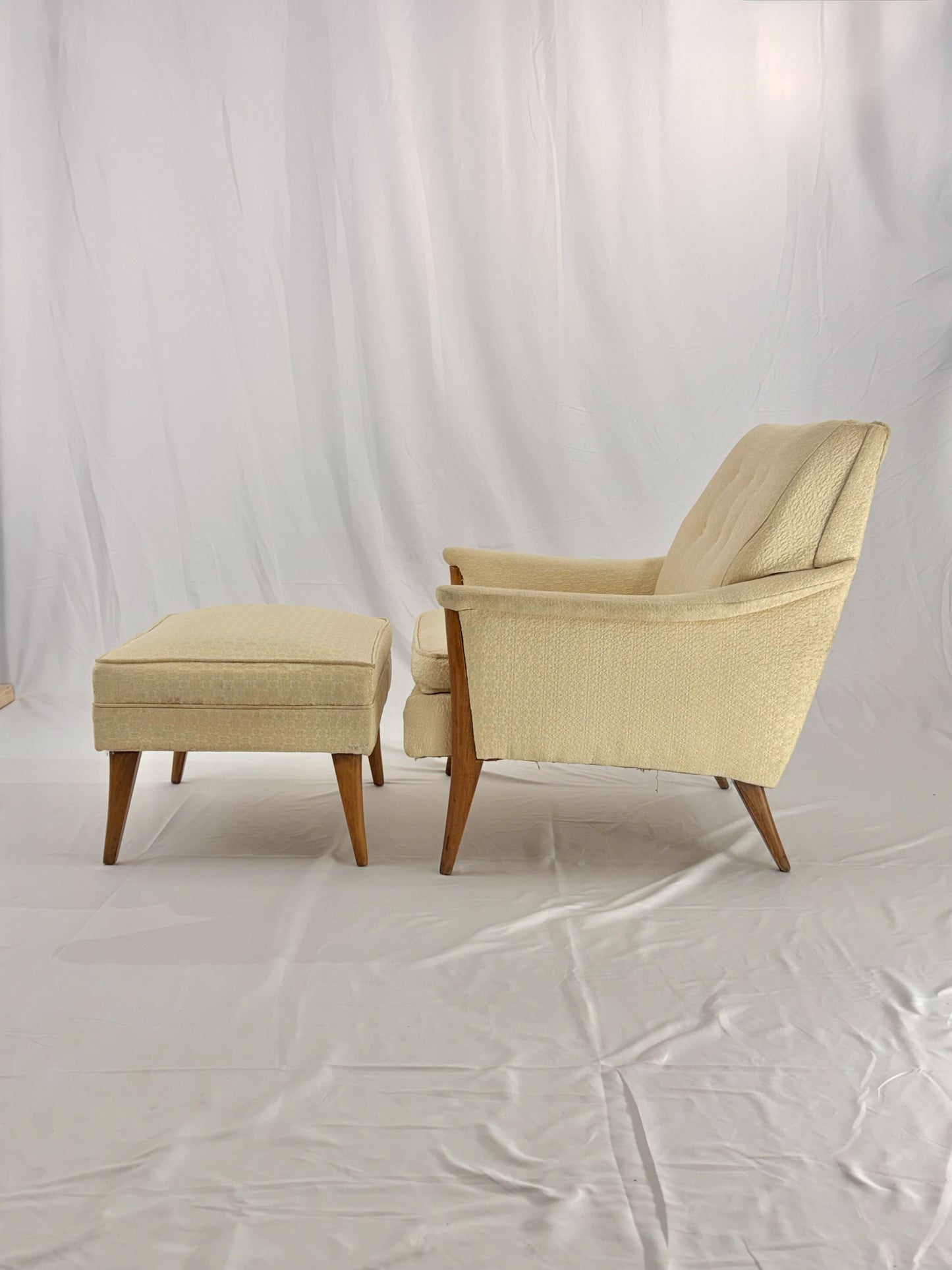 Beige armchair and ottoman on a white background