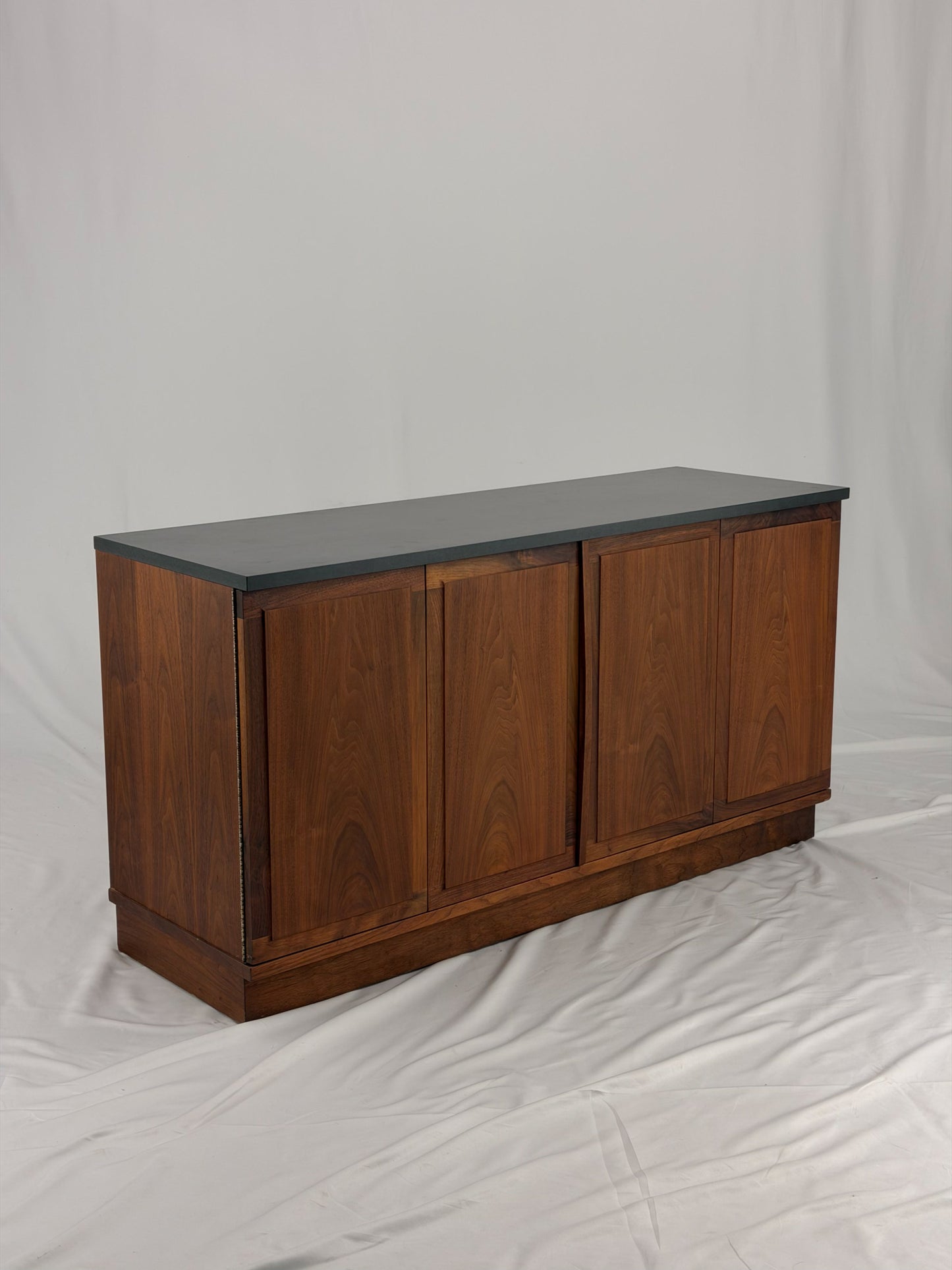Wooden sideboard with a black countertop on a plain background