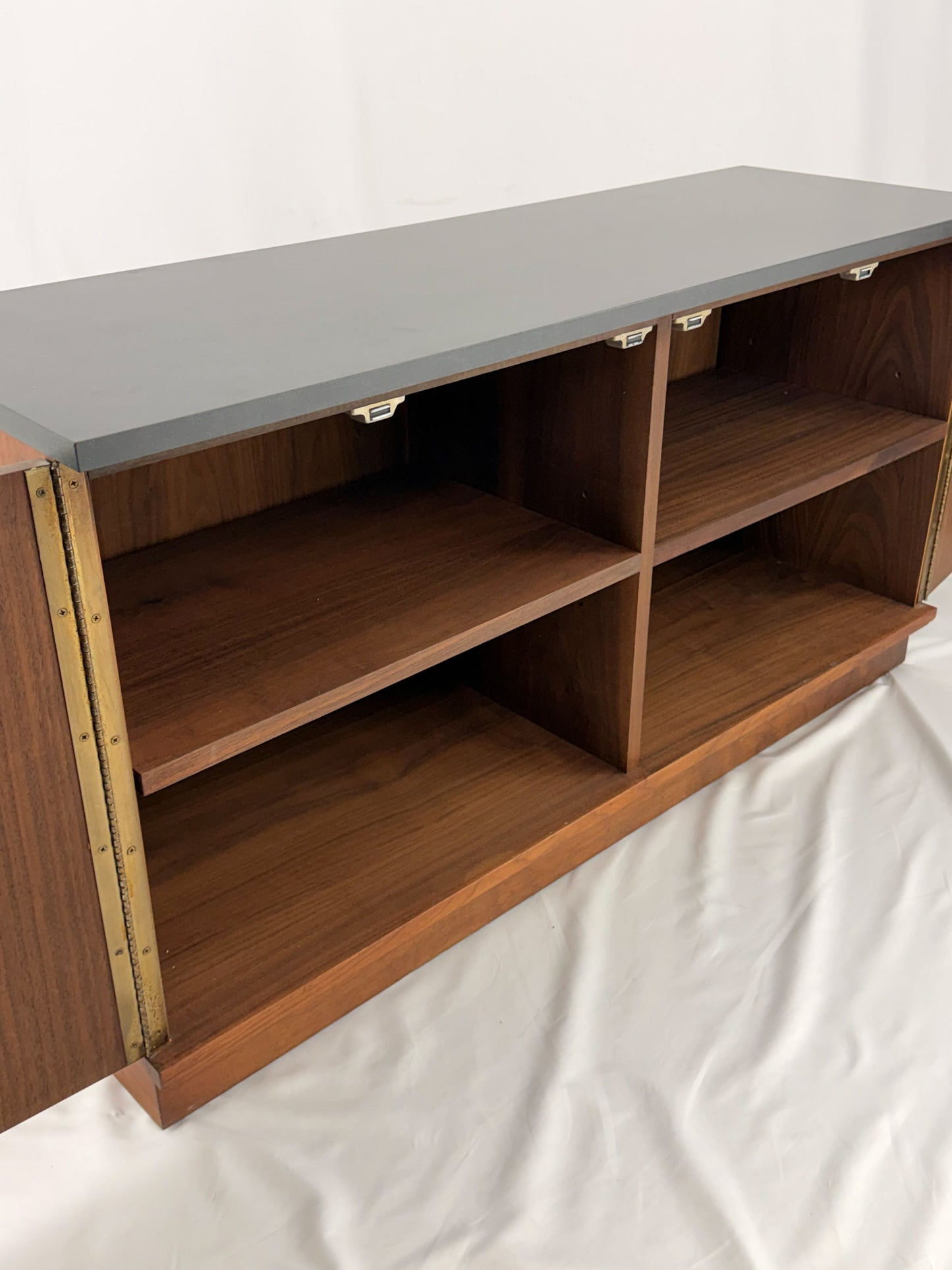 Wooden sideboard with a black countertop on a plain background