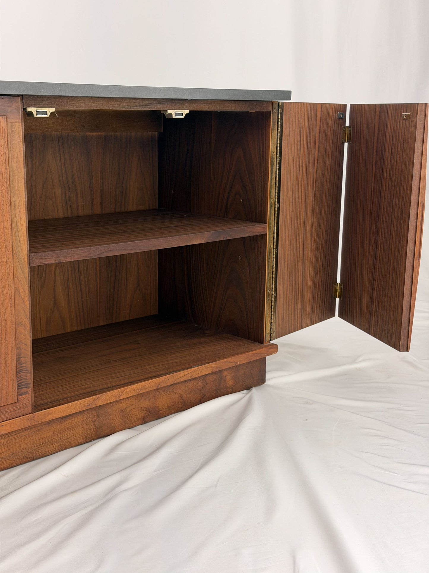Wooden sideboard with a black countertop on a plain background