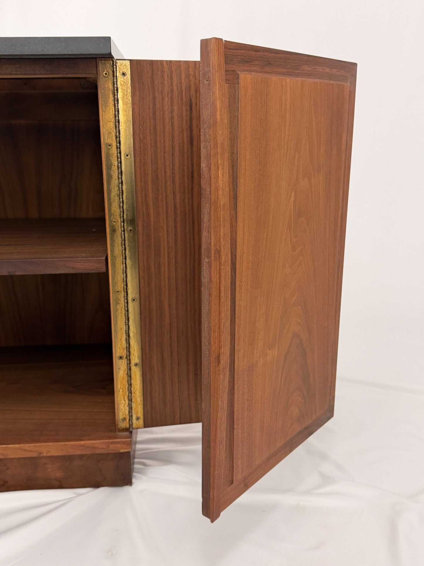 Wooden sideboard with a black countertop on a plain background
