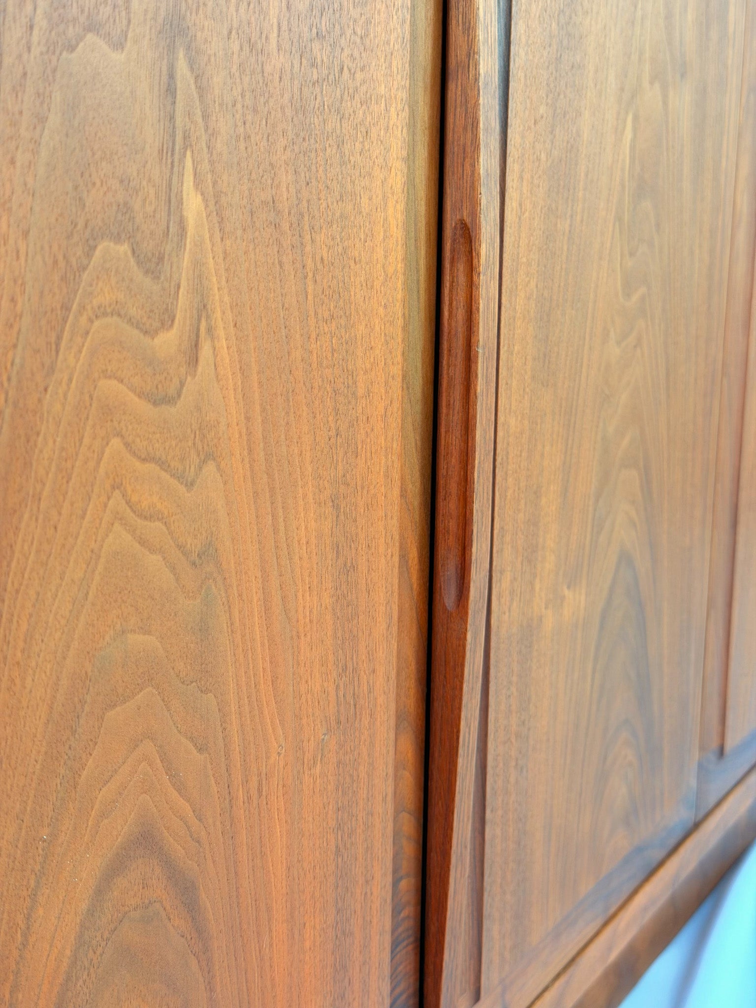 Wooden sideboard with a black countertop on a plain background