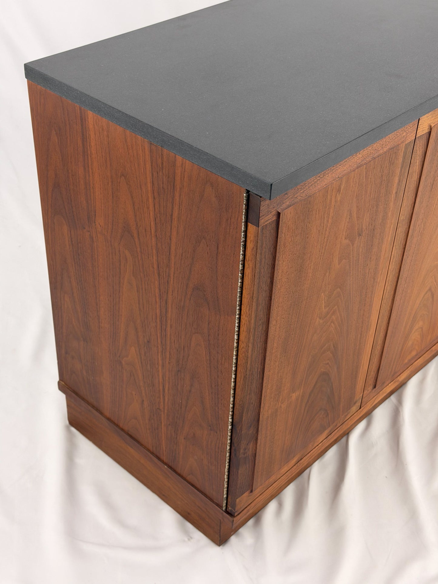 Wooden sideboard with a black countertop on a plain background