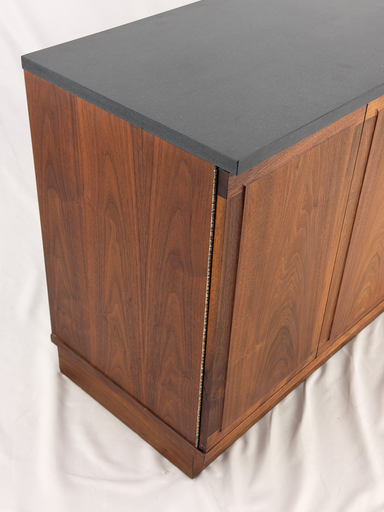 Wooden sideboard with a black countertop on a plain background