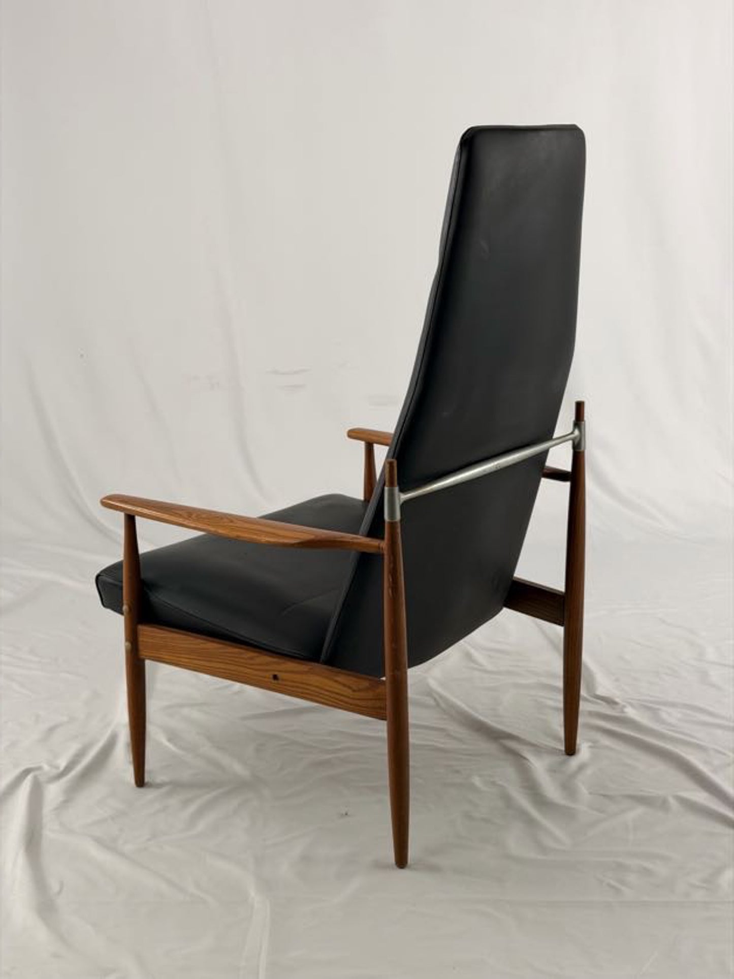 Black leather armchair with wooden frame on a white background