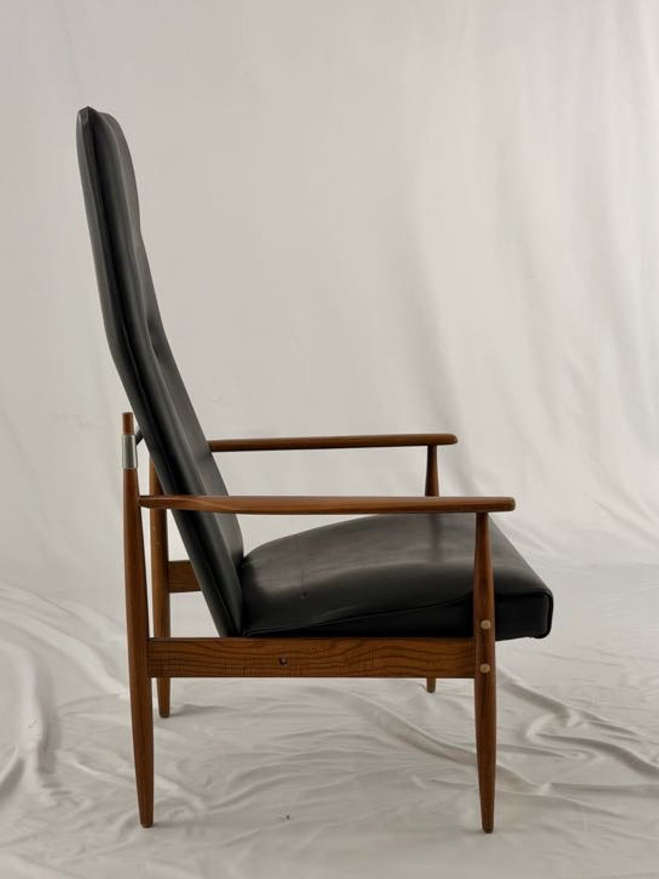 Black leather armchair with wooden frame on a white background