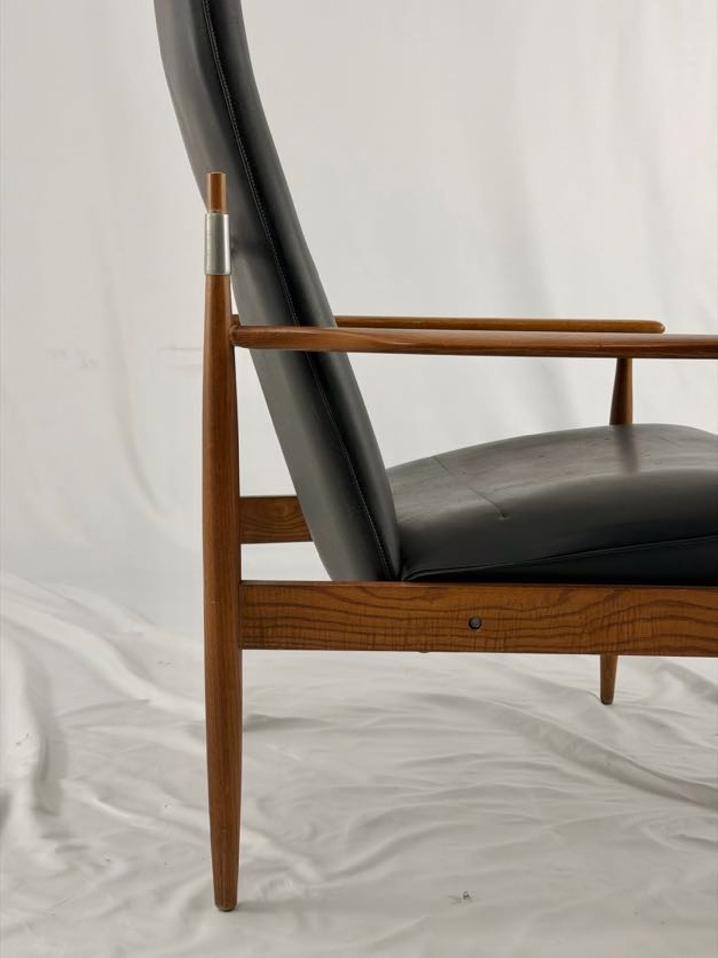Black leather armchair with wooden frame on a white background