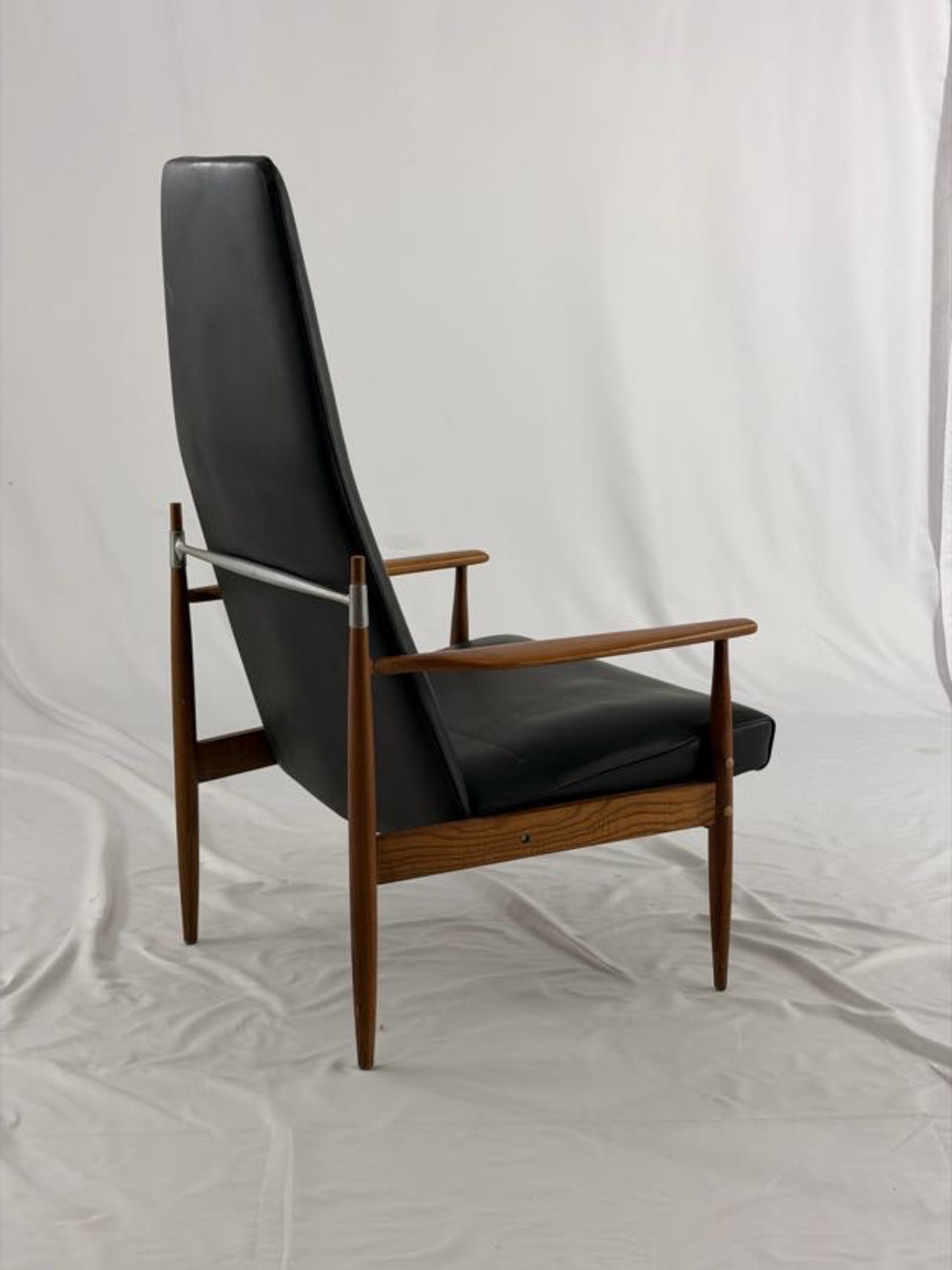Black leather armchair with wooden frame on a white background