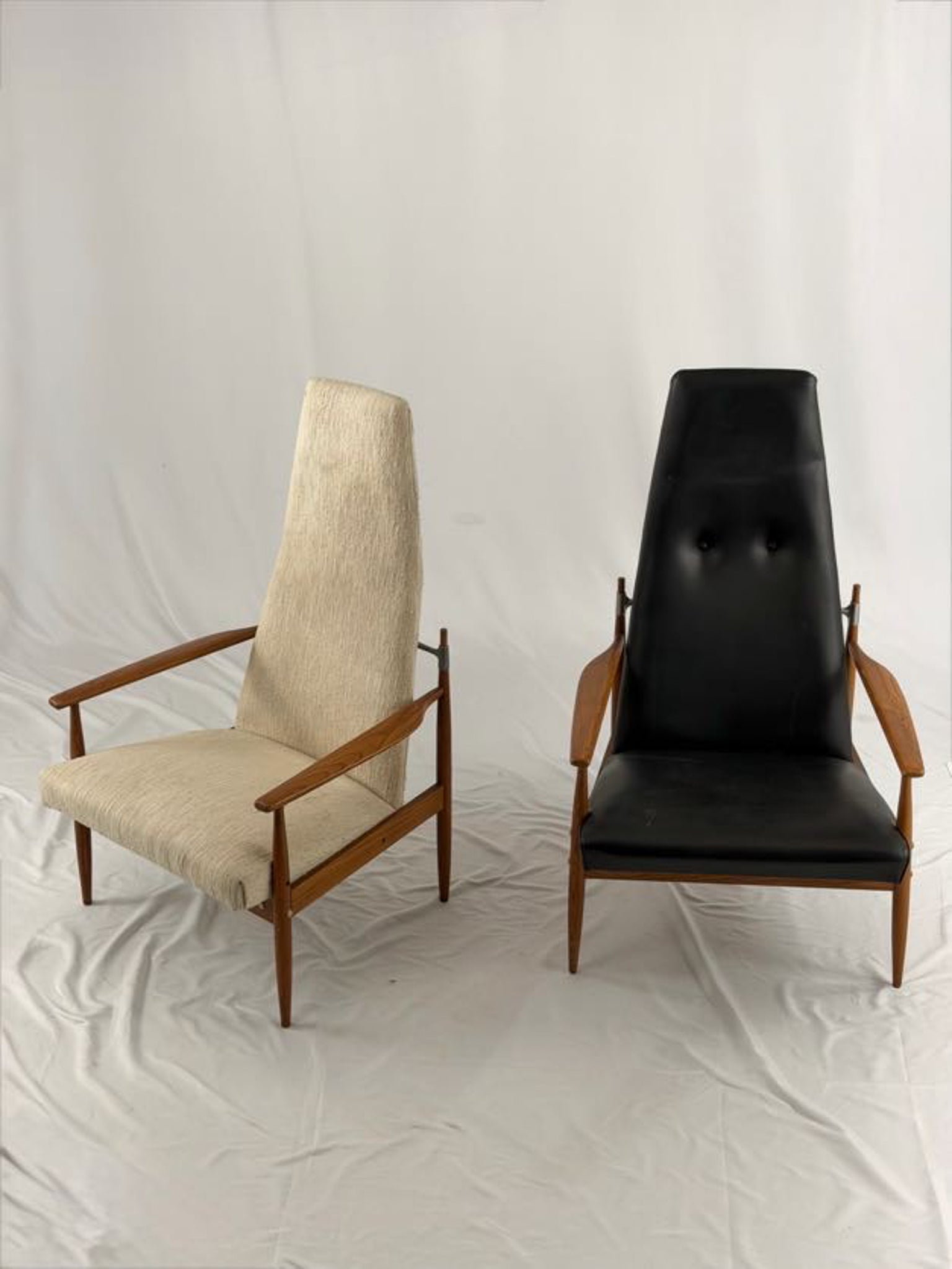 Two chairs, one beige and one black, on a white background
