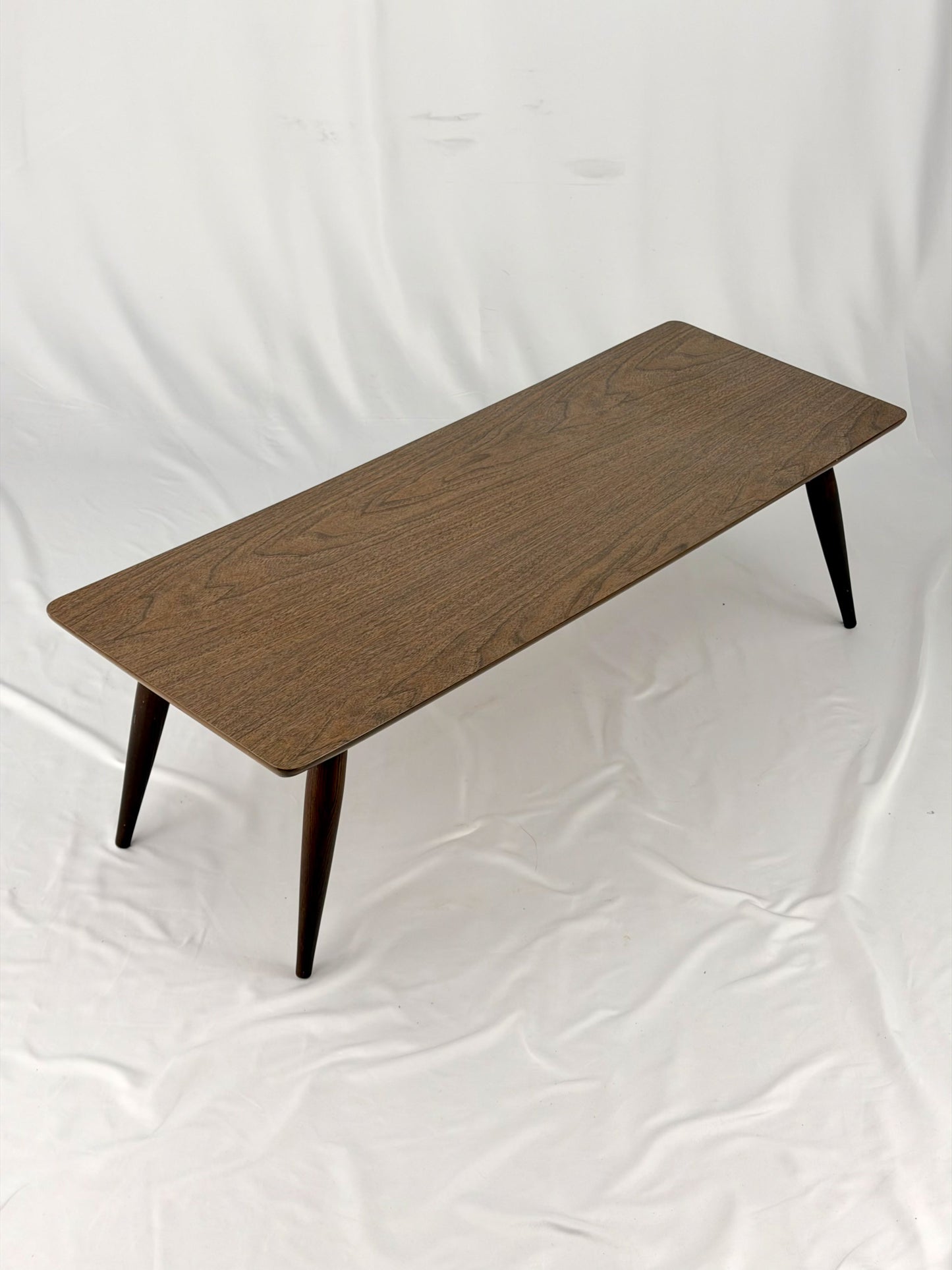 Wooden coffee table with four legs on a white background
