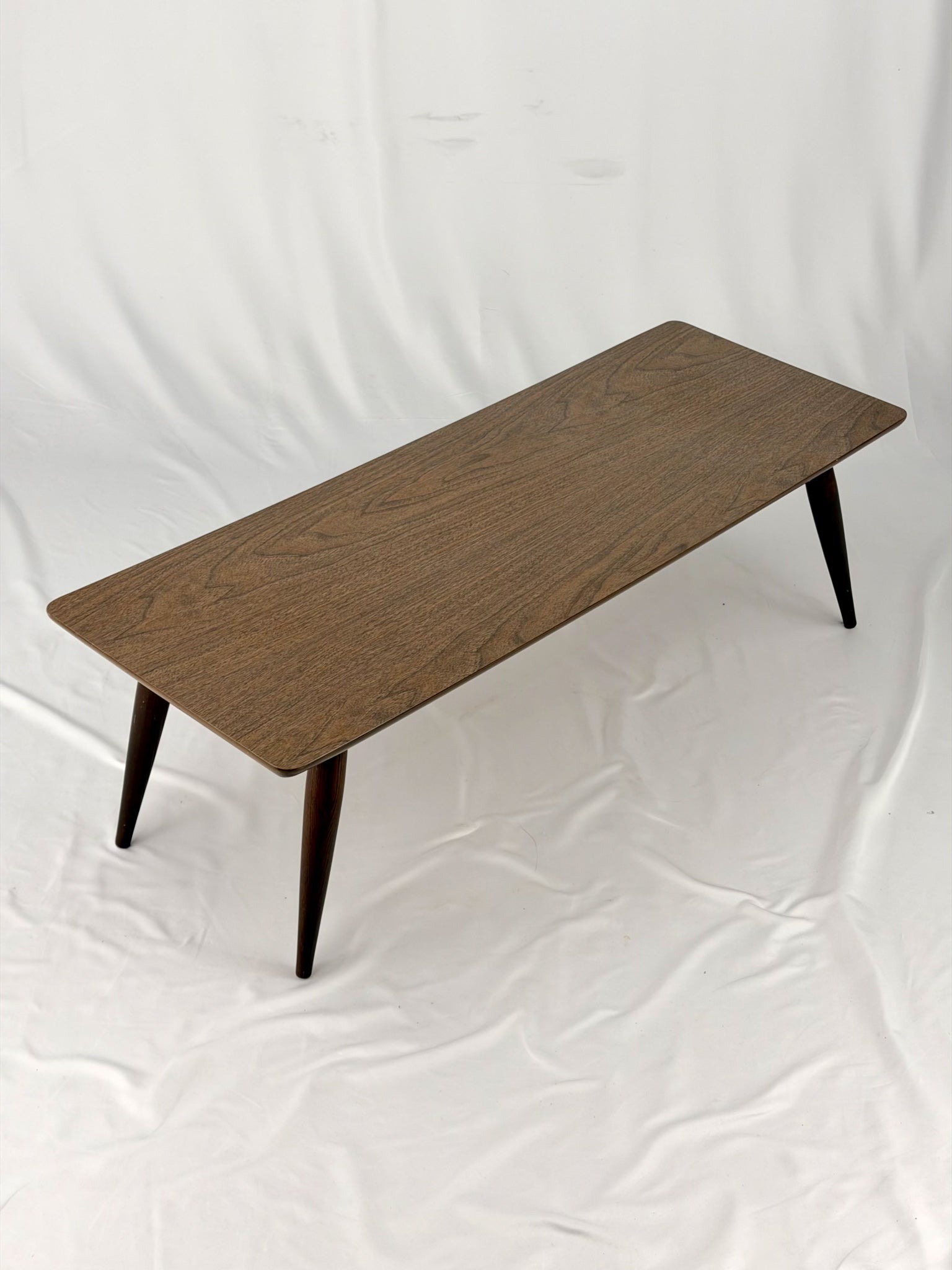 Wooden coffee table with four legs on a white background