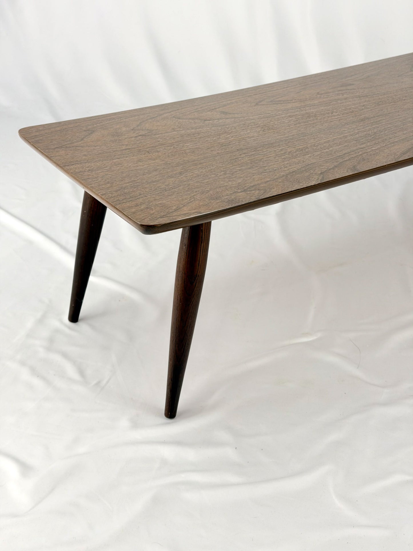 Wooden coffee table with four legs on a white background