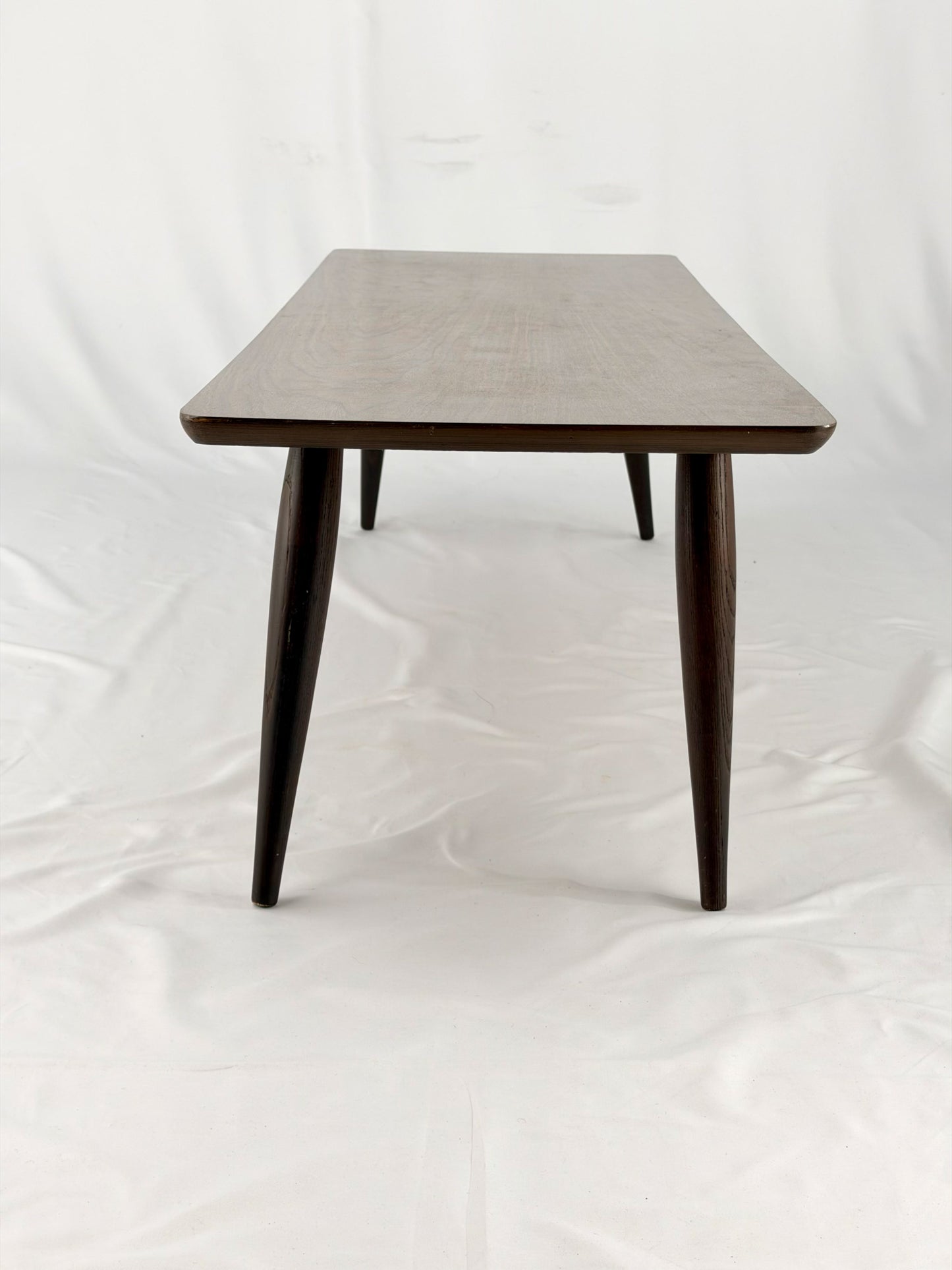 Wooden coffee table with four legs on a white background