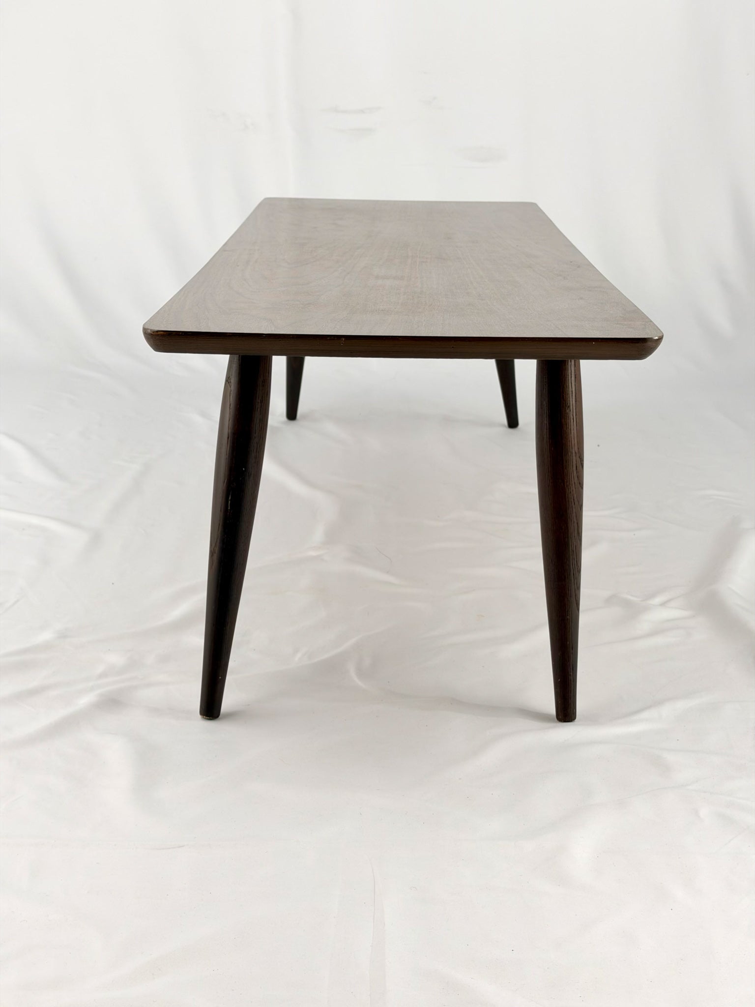Wooden coffee table with four legs on a white background