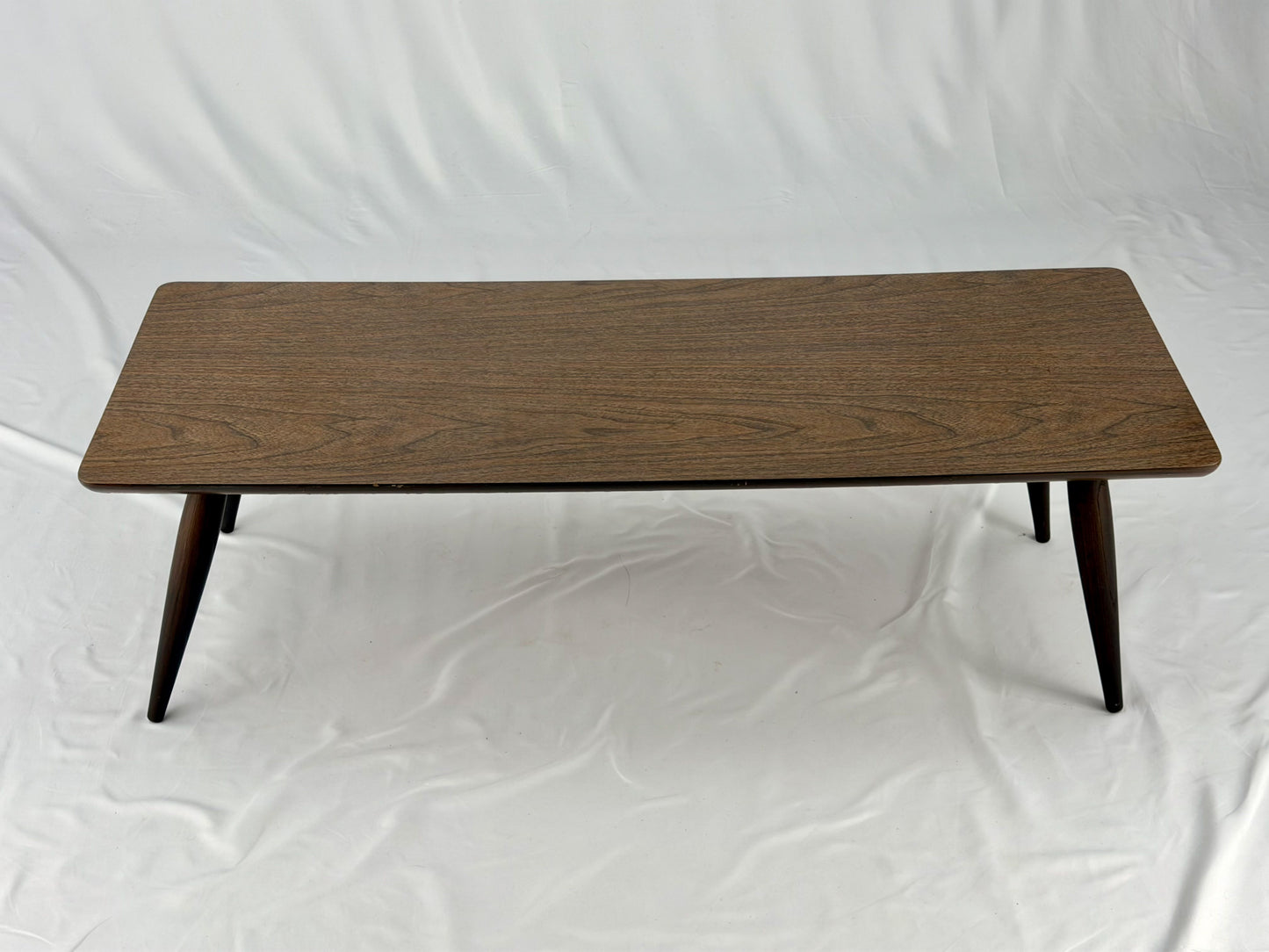 Wooden coffee table with four legs on a white background