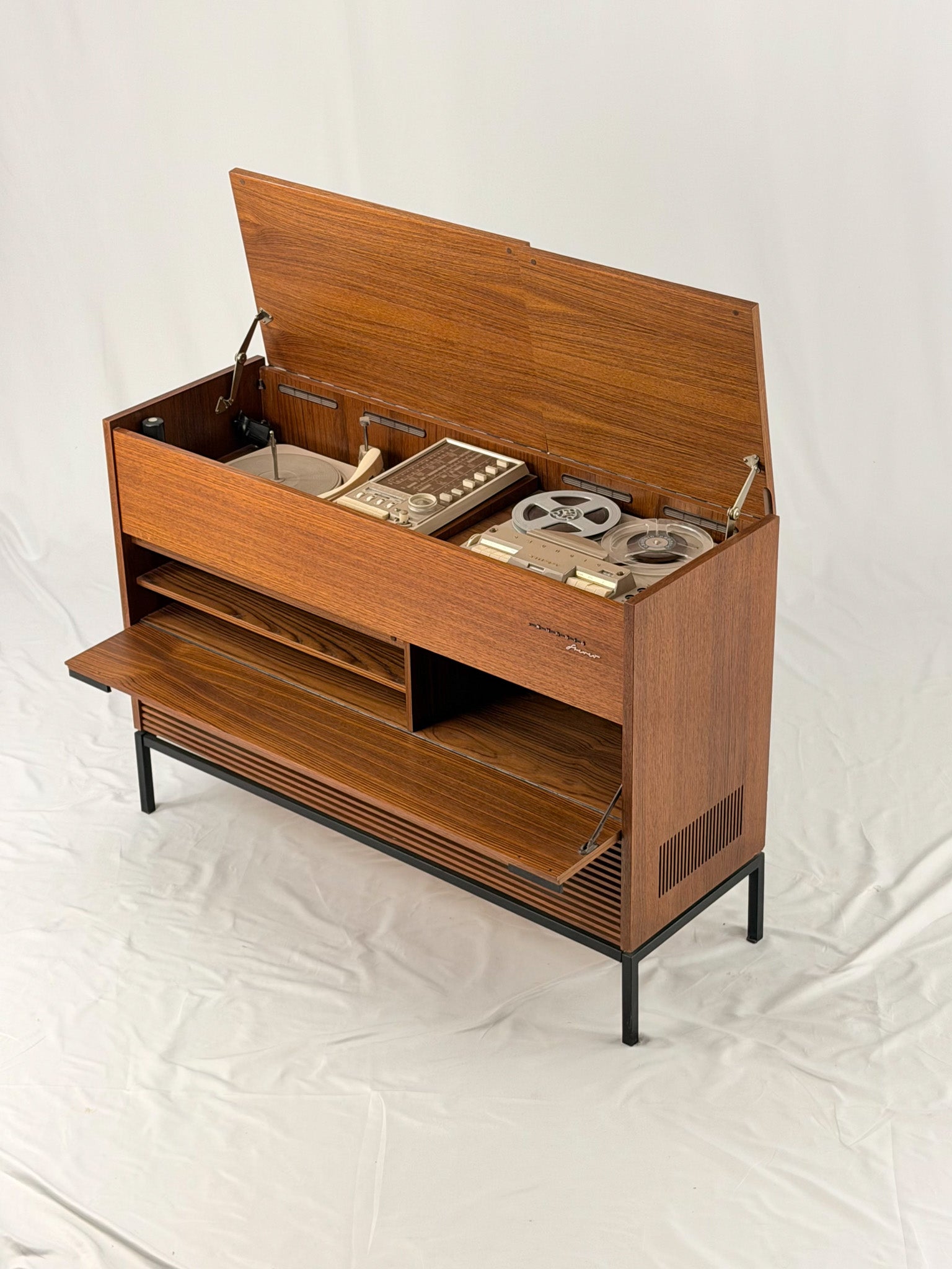 Vintage record player with a turntable and control panel on a wooden surface.