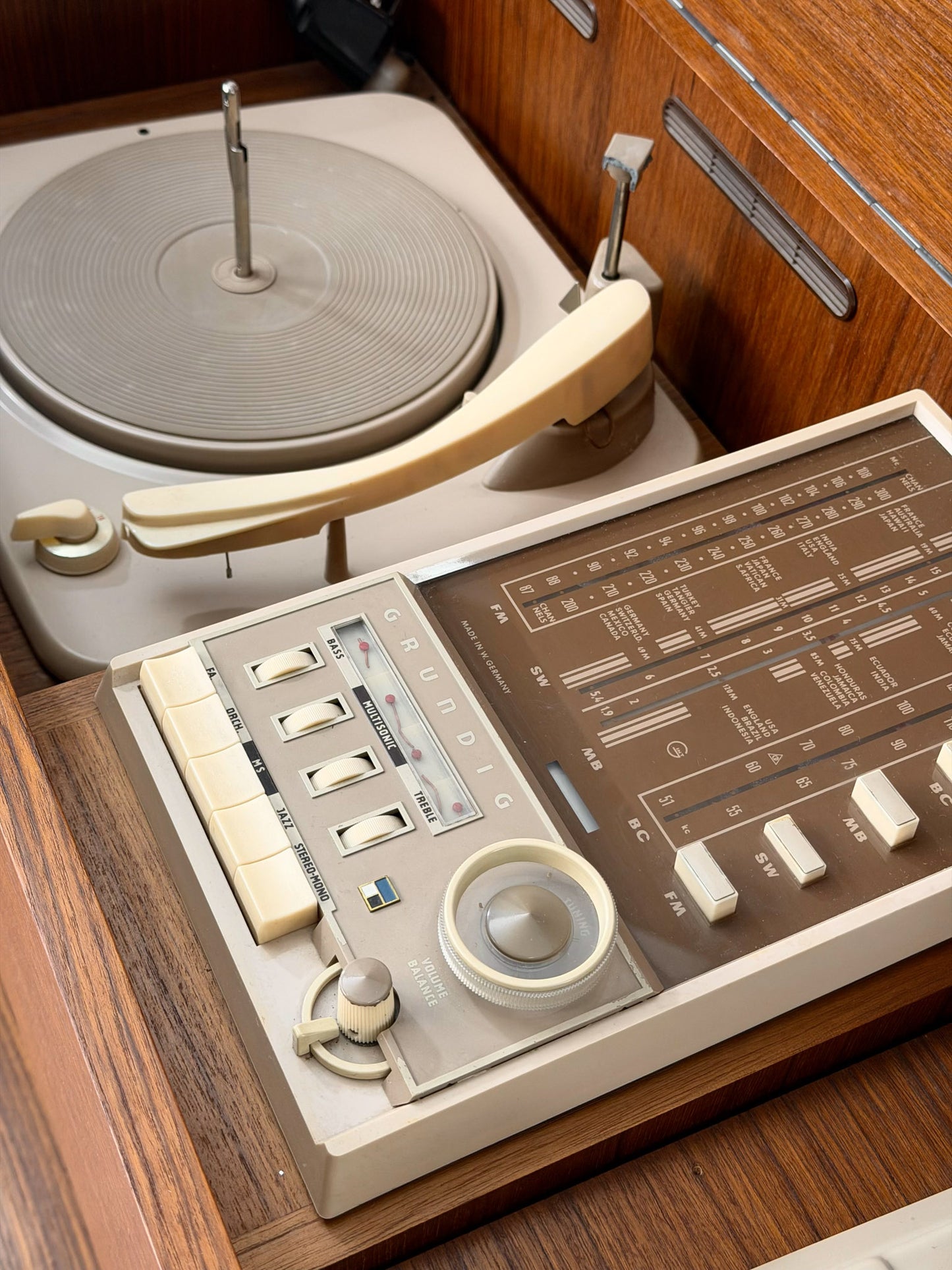 Vintage record player with a turntable and control panel on a wooden surface.